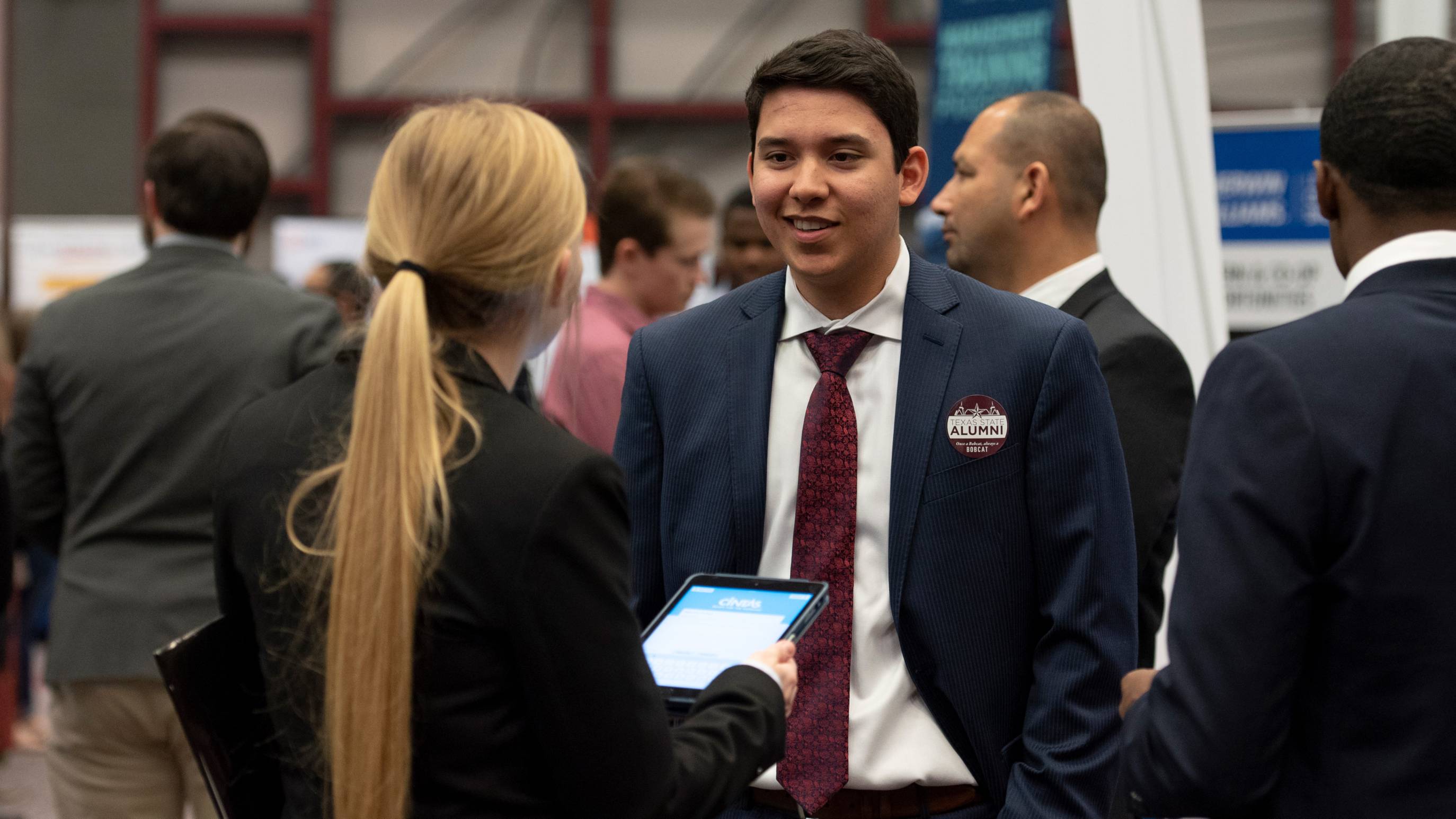 Two people in business attire talking at a career event
