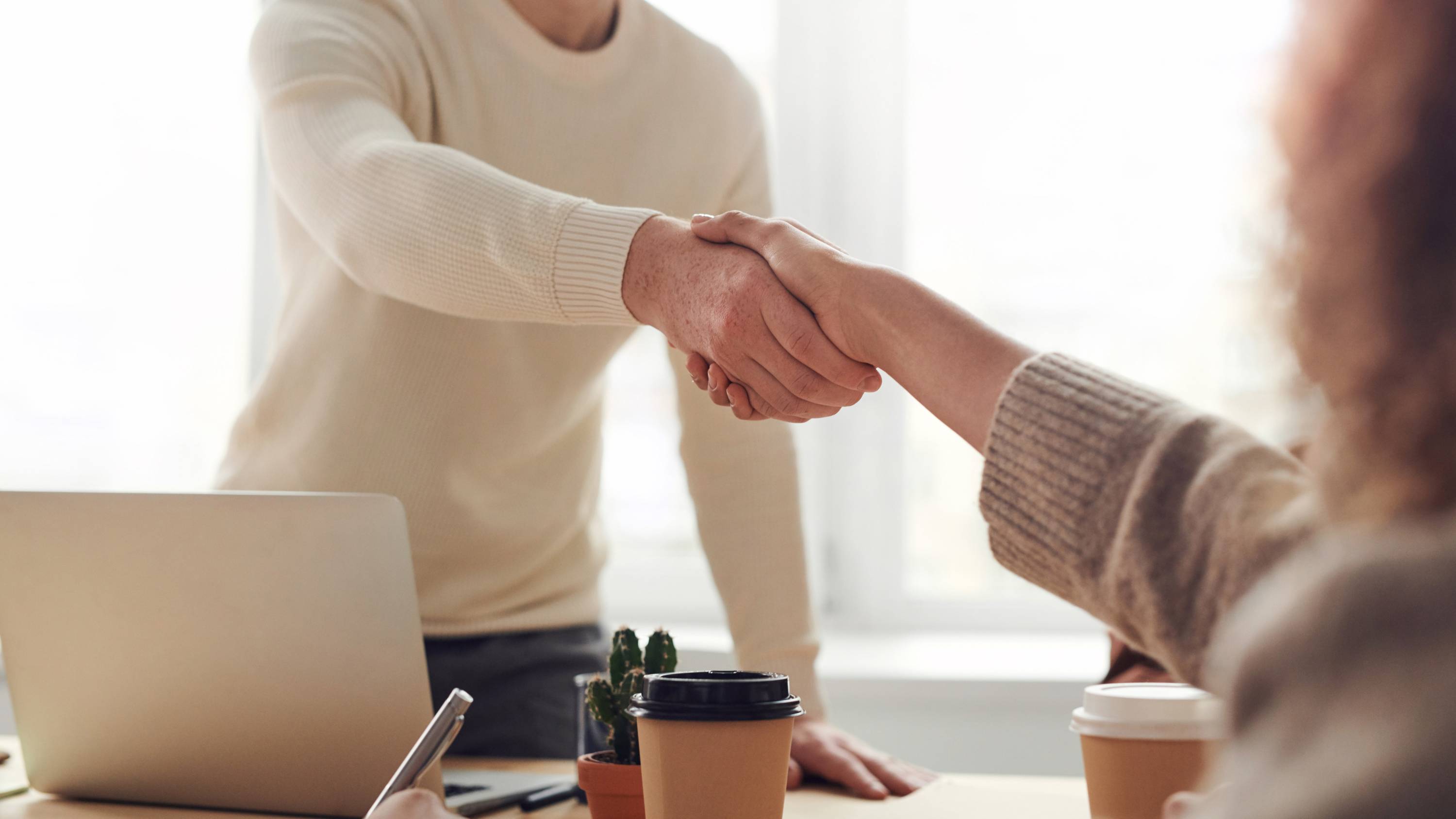 Two people shaking hands in an office