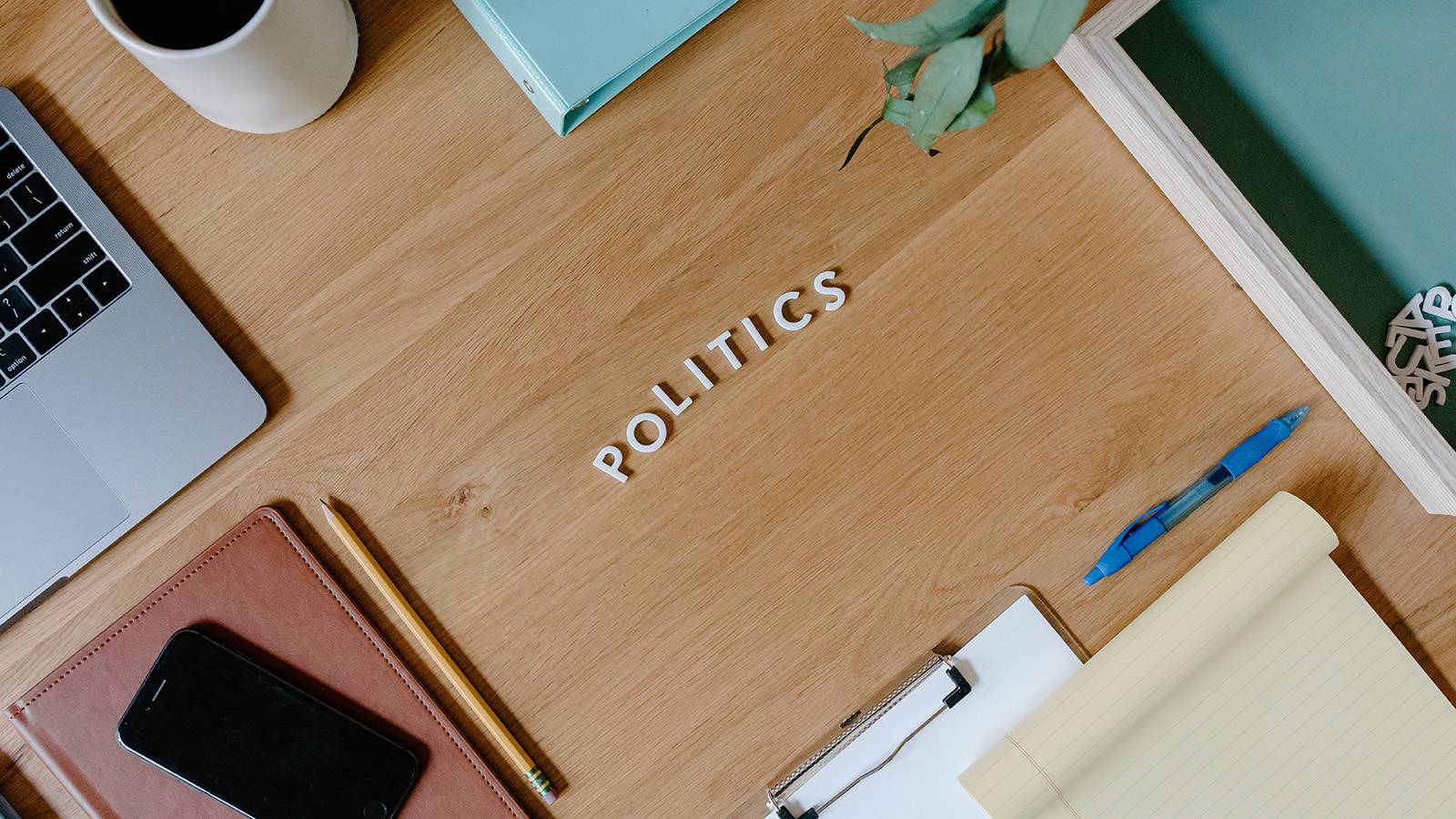 Desk with office supplies and letters that read "politics"