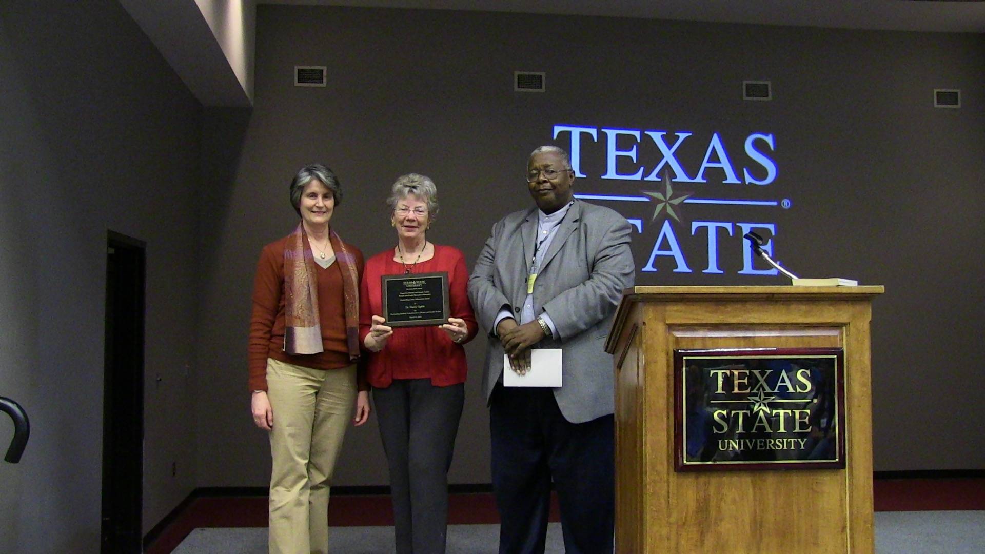 Dr. Sharon Ugalde receiving award, along with Dr. Catherine Jaffe, and Dr. Audwin Anderson