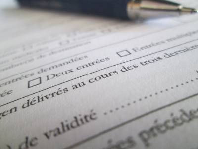 Image of form in French with ball-point pen in background