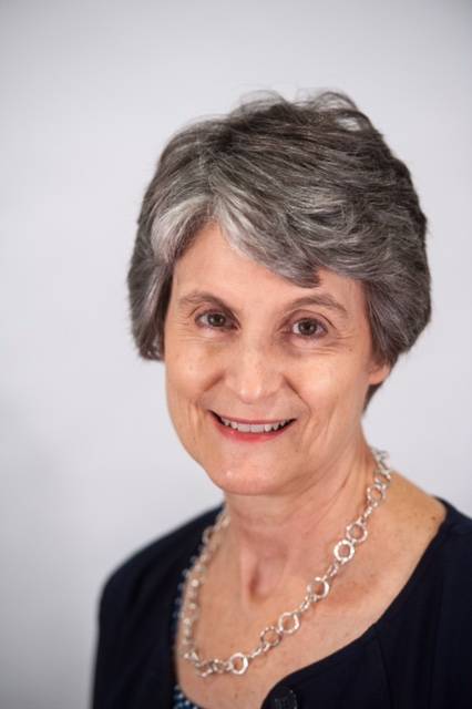 woman wearing necklace in front of light background