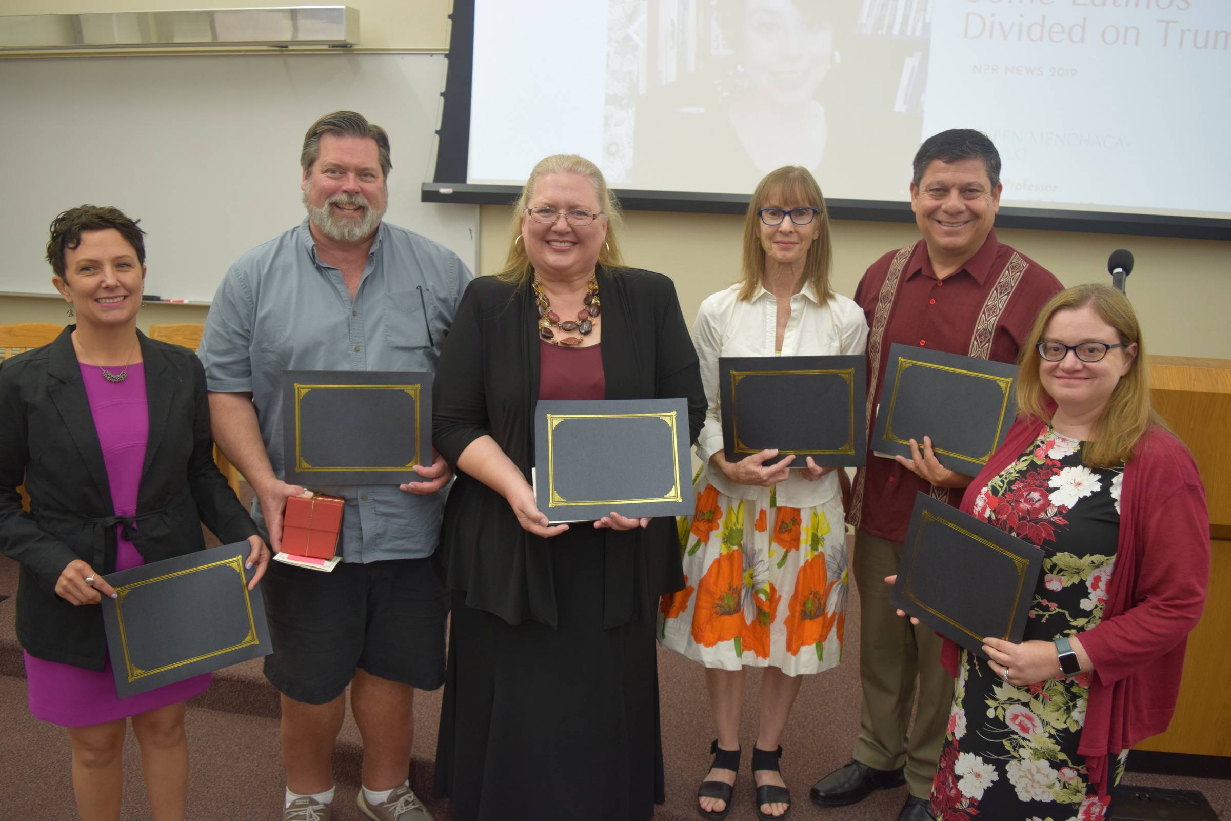 Six people holding awards