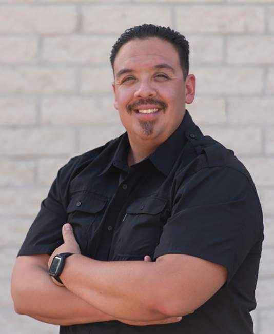 Headshot of Rene Gonzales with arms crossed wearing a black shirt