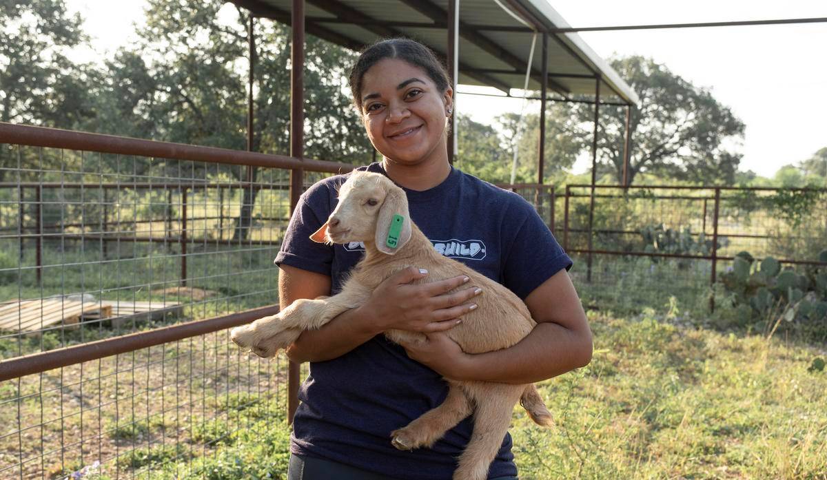 female student holding baby goat