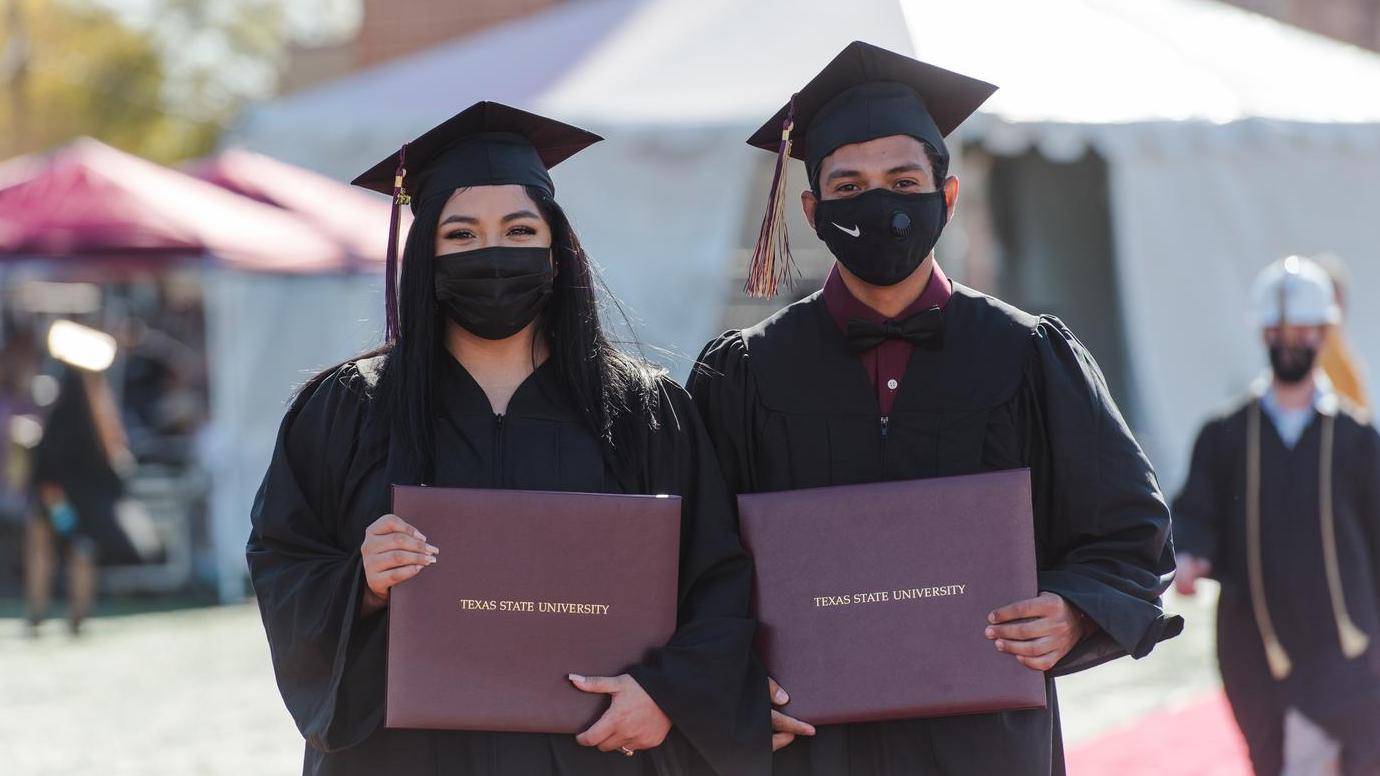 female and male graduates holding degrees