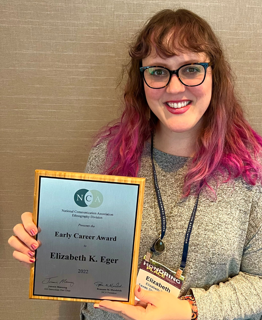 Elizabeth Eger holding her early career research award from the Ethnography Division.