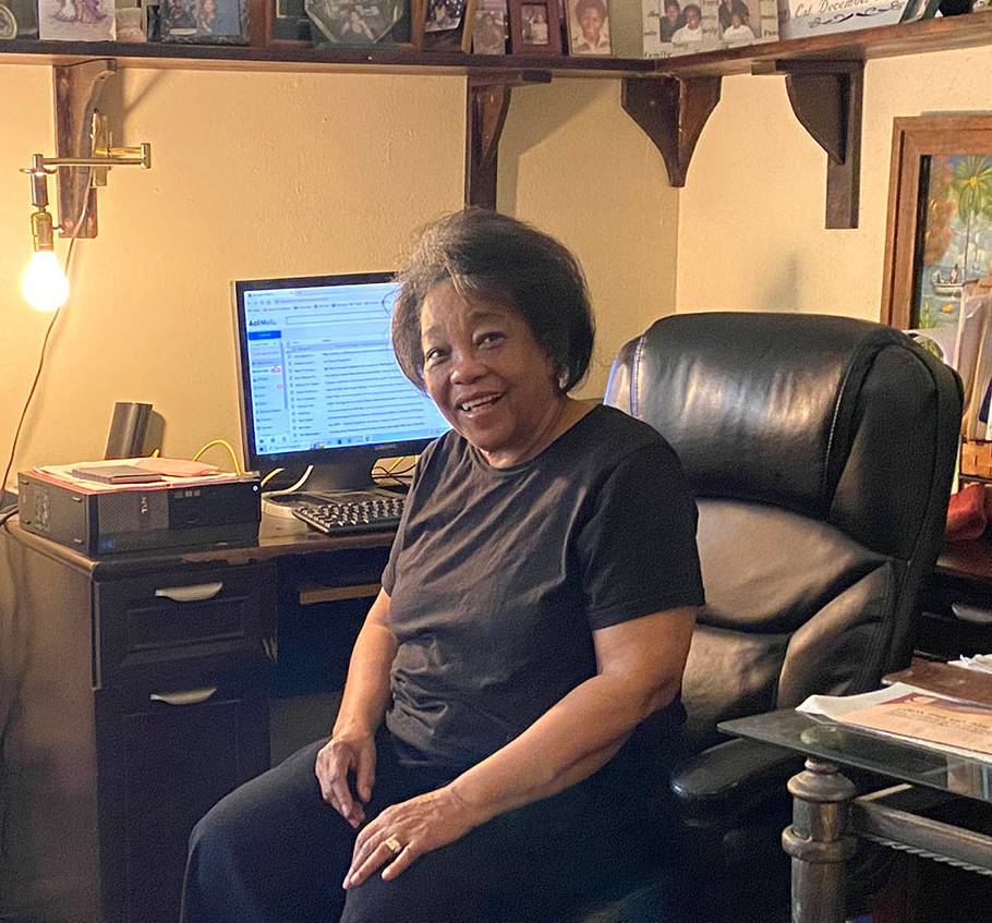 Black woman sitting in leather chair in front of computer