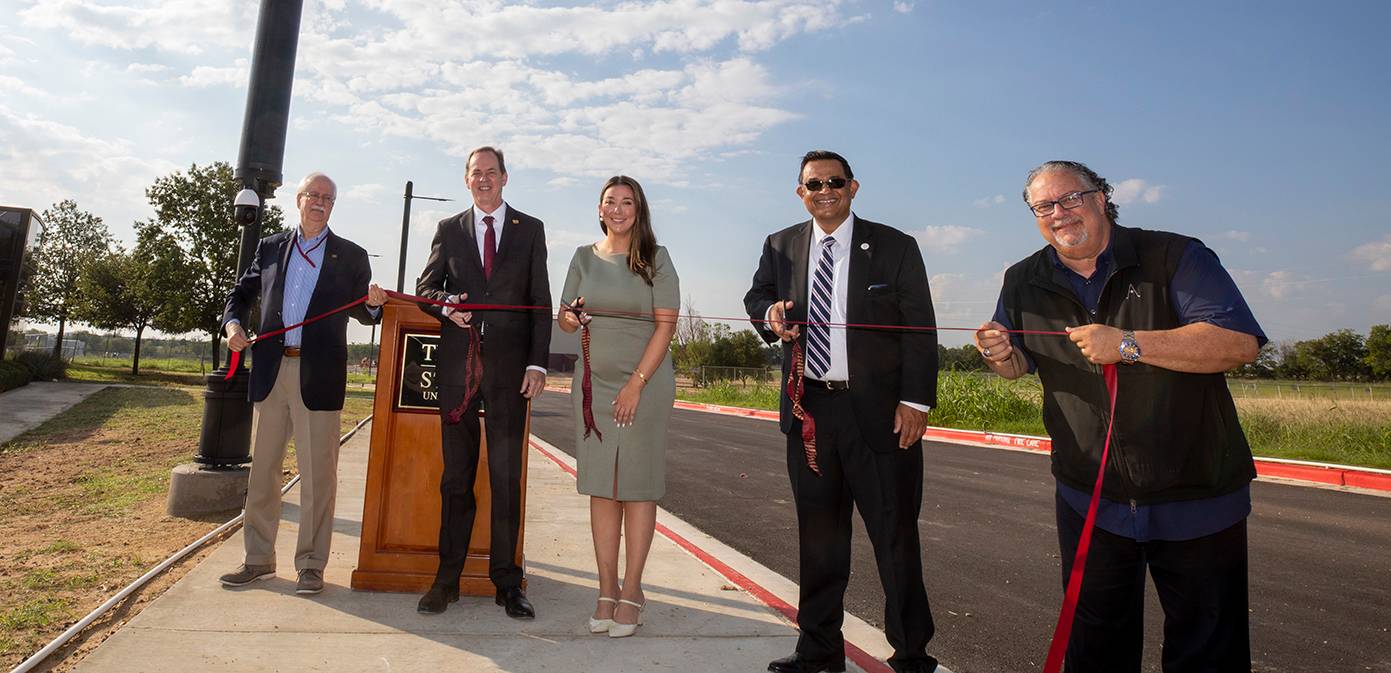 ribbon cutting ceremony with 4 men and one woman