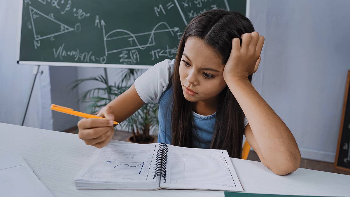 middle school student looking at notebook paper with graph on it