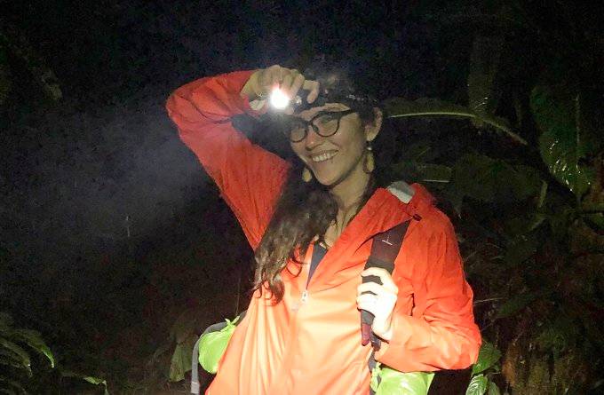 female student wearing orange jacket and headlamp