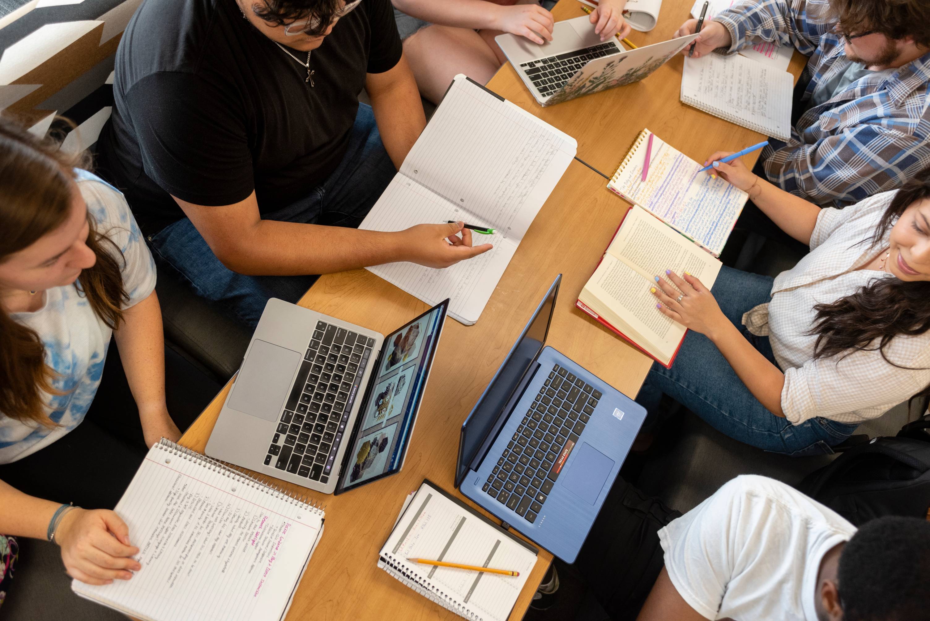 Students studying with laptops and books