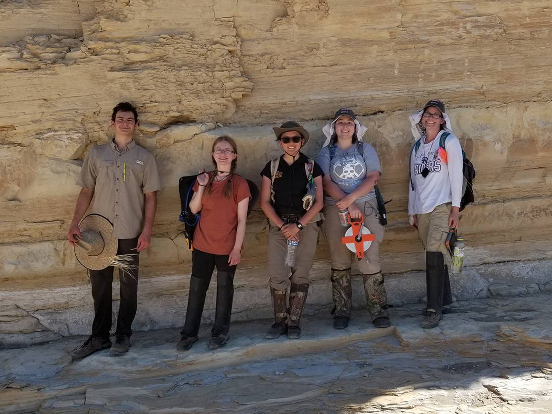 five students standing next to large rock in big bend national park
