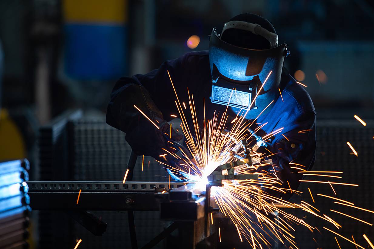 person welding metal with sparks flying