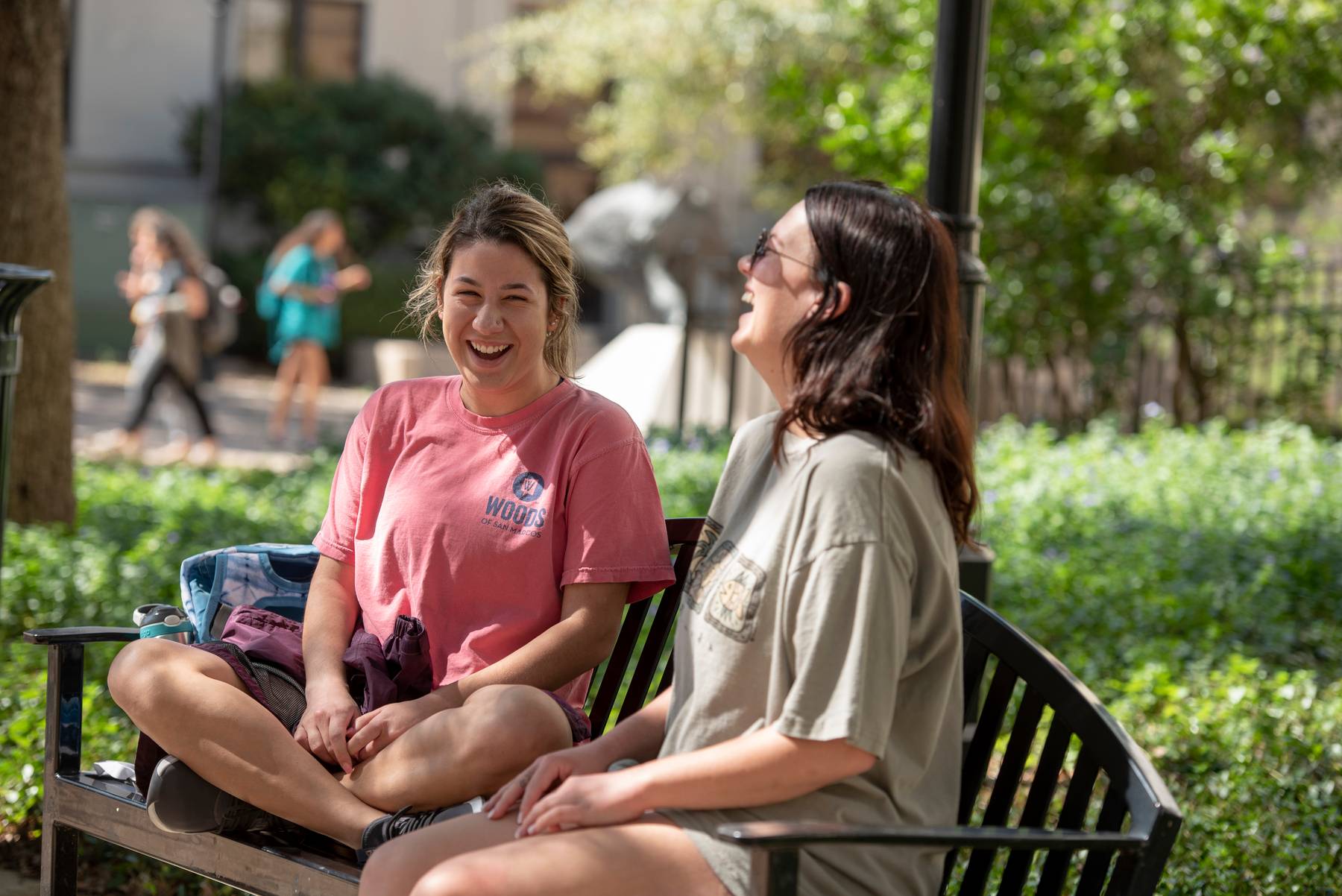 Students sitting on a bench outside on campus