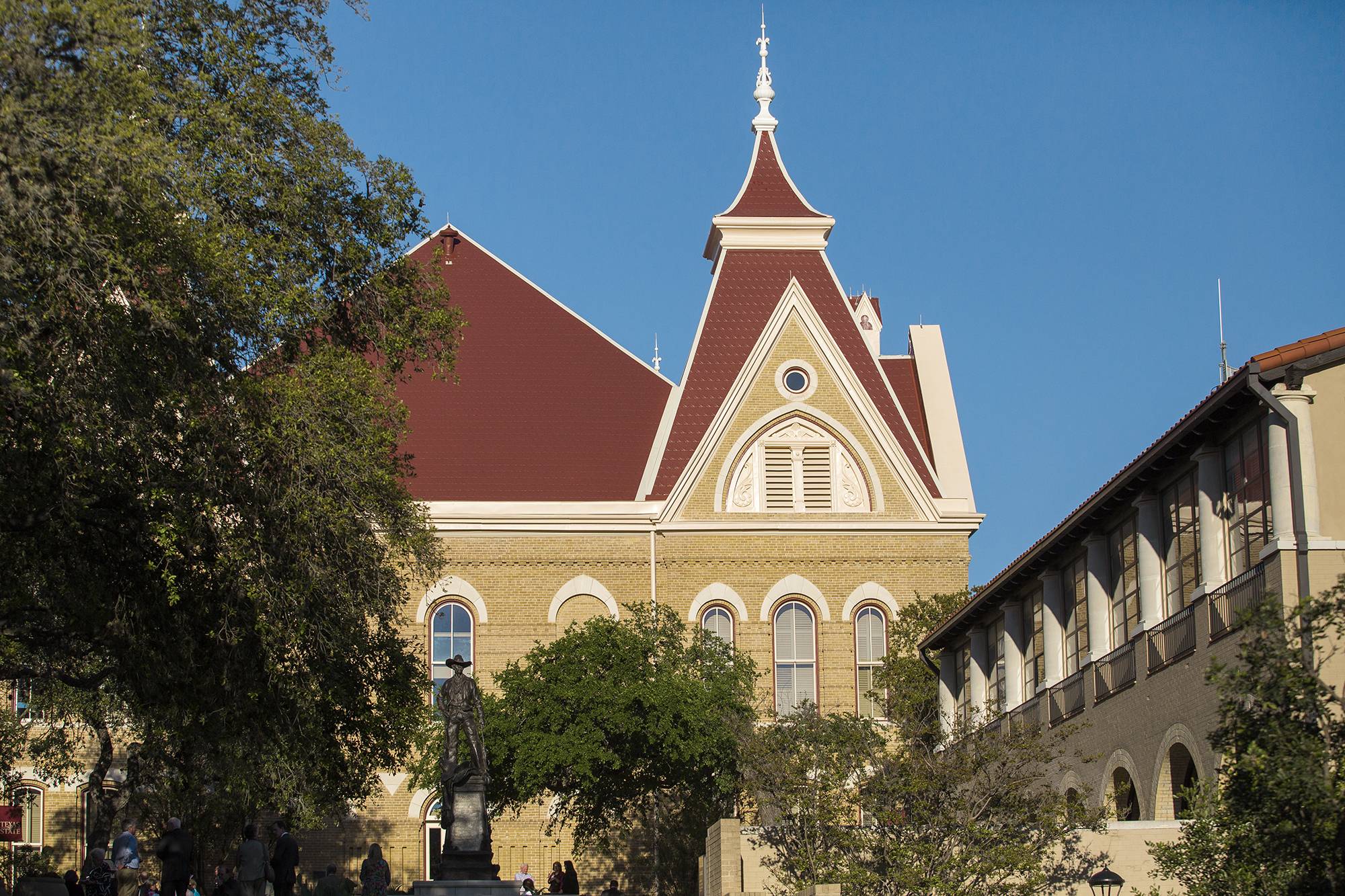 Old Main building rooftop with trees and sky.