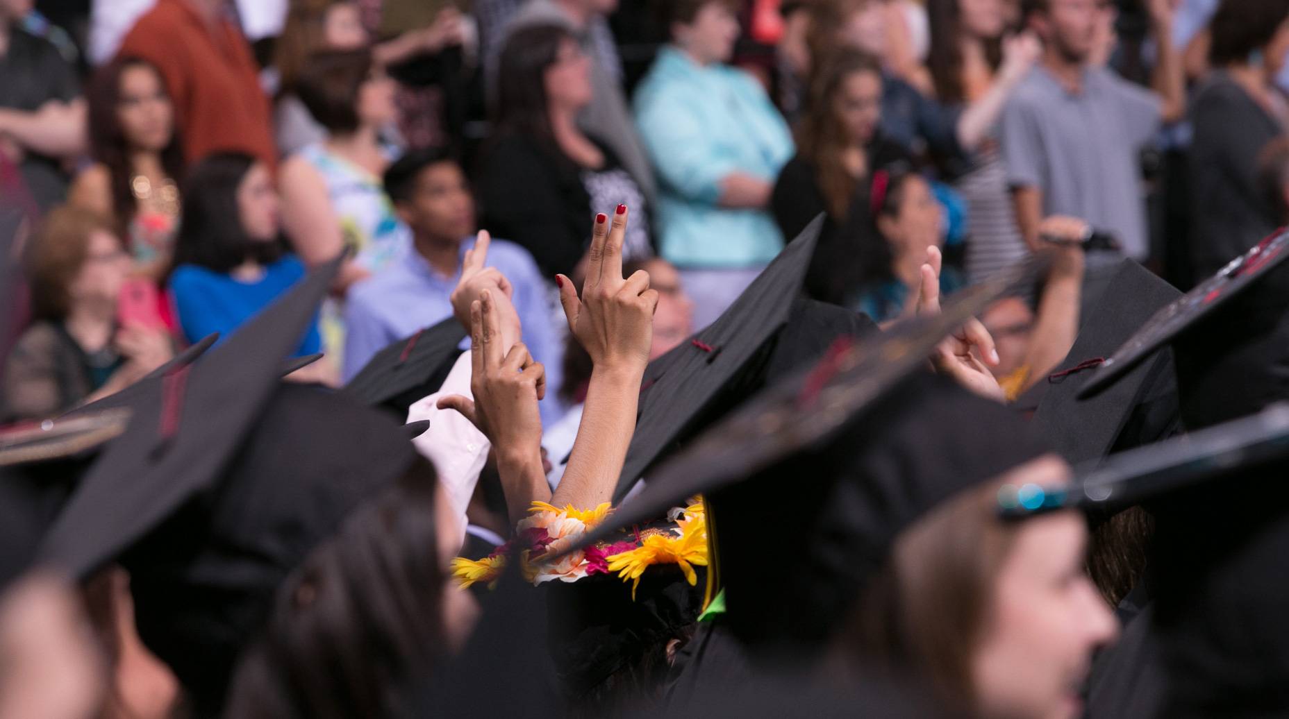 an image of graduating students during graduation, wearing their caps