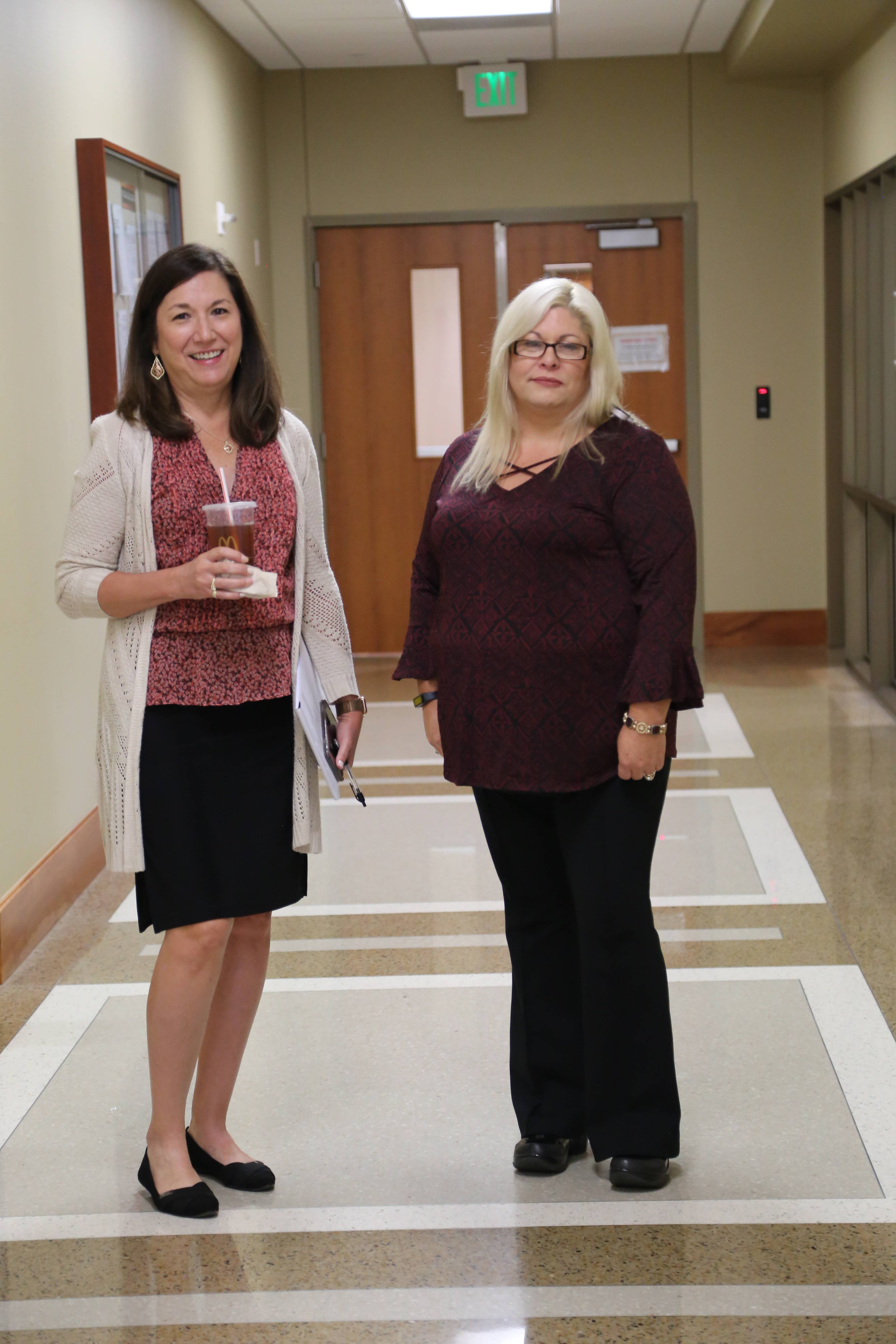 Two Nursing faculty standing in hallway