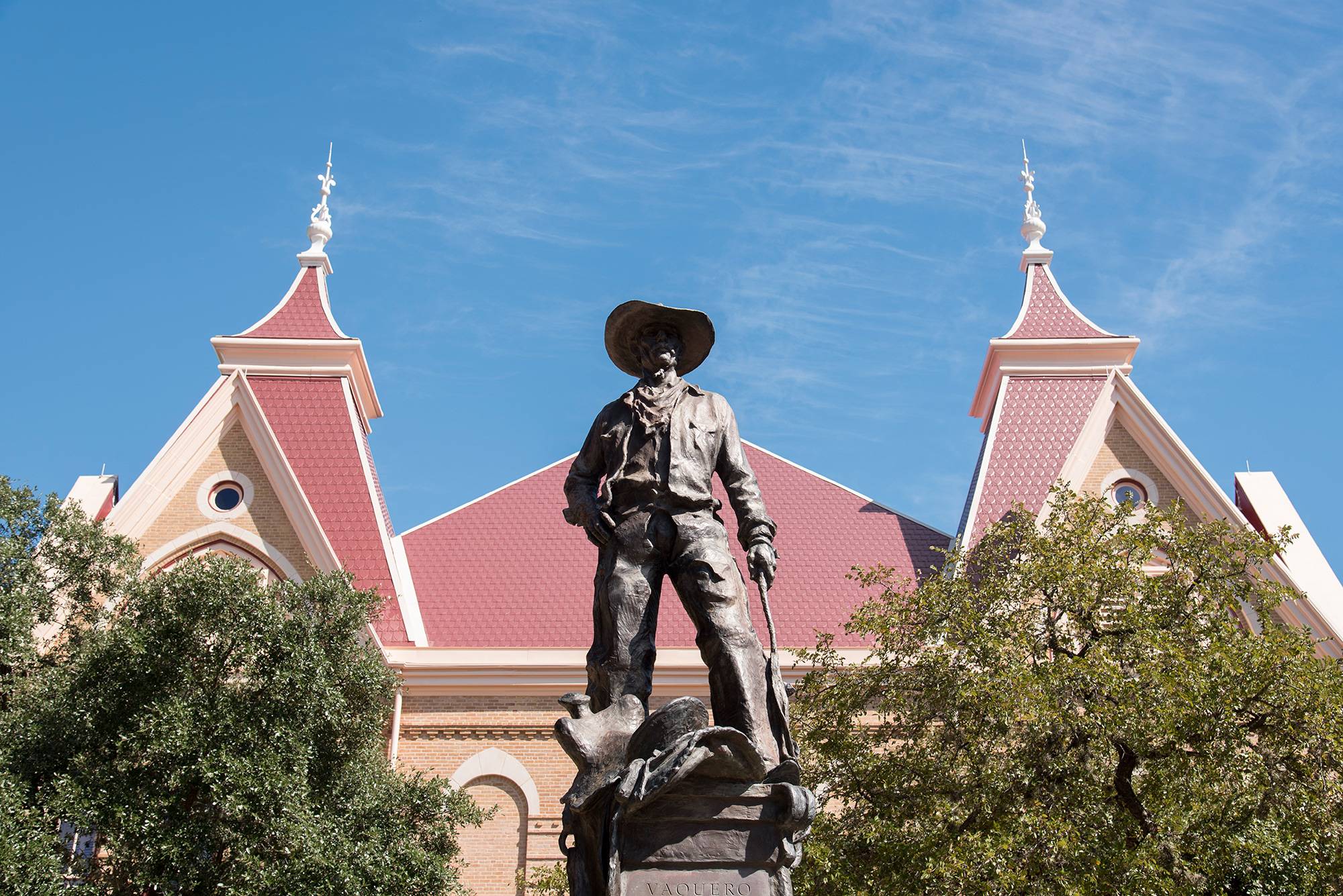 the vaquero statue with old main the background