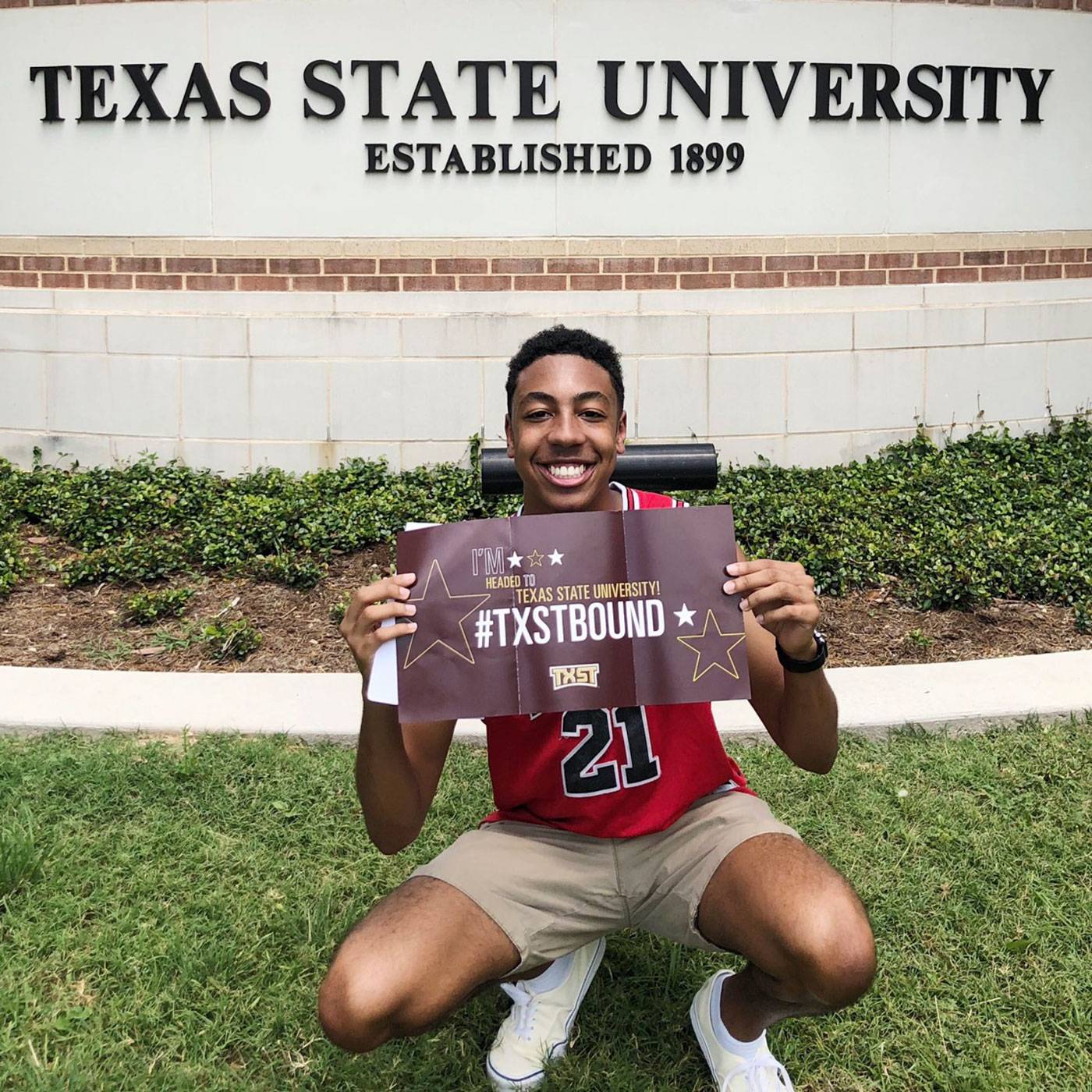 a student holds a banner that says #txstbound