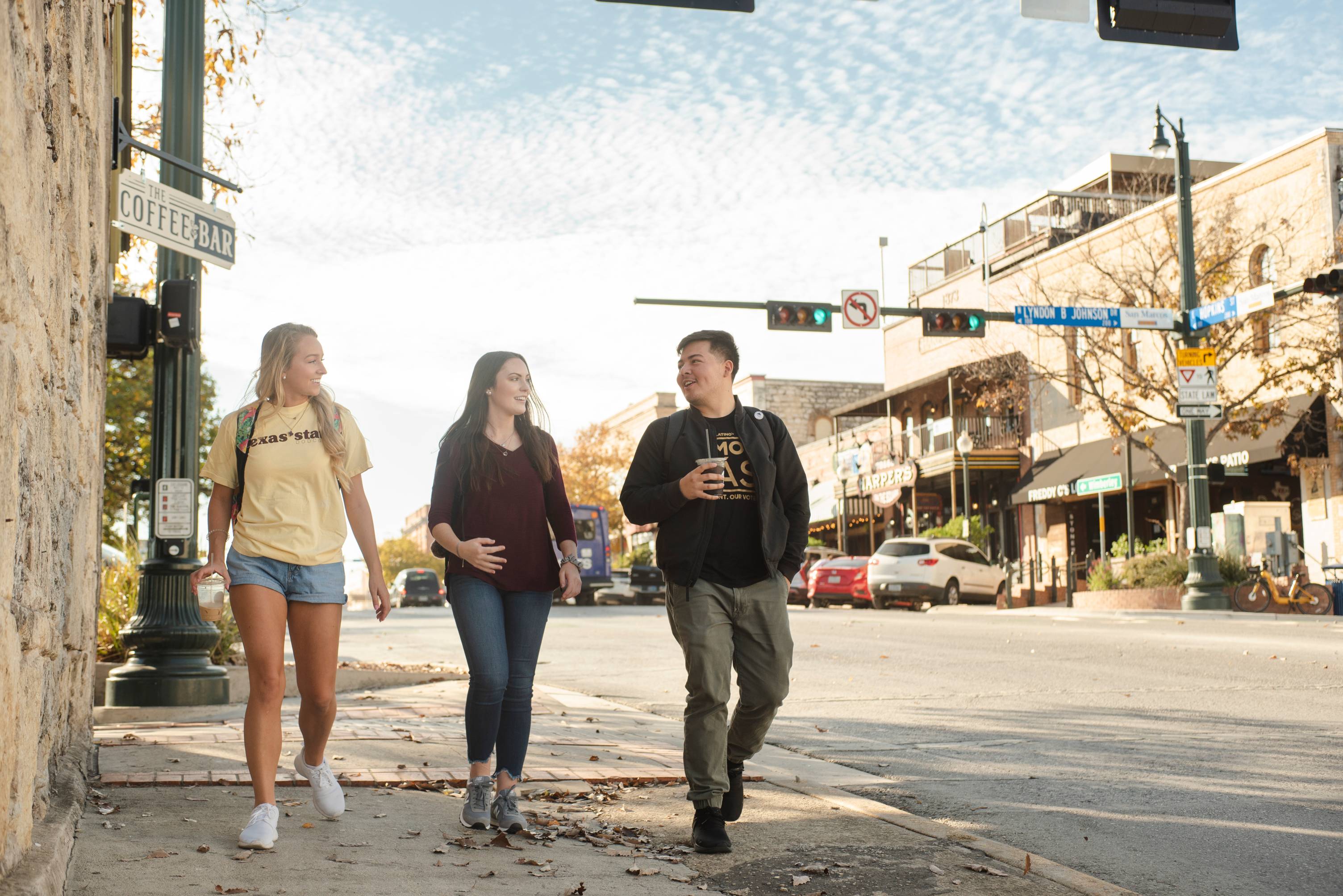 Three students walking in downtown San Marcos.