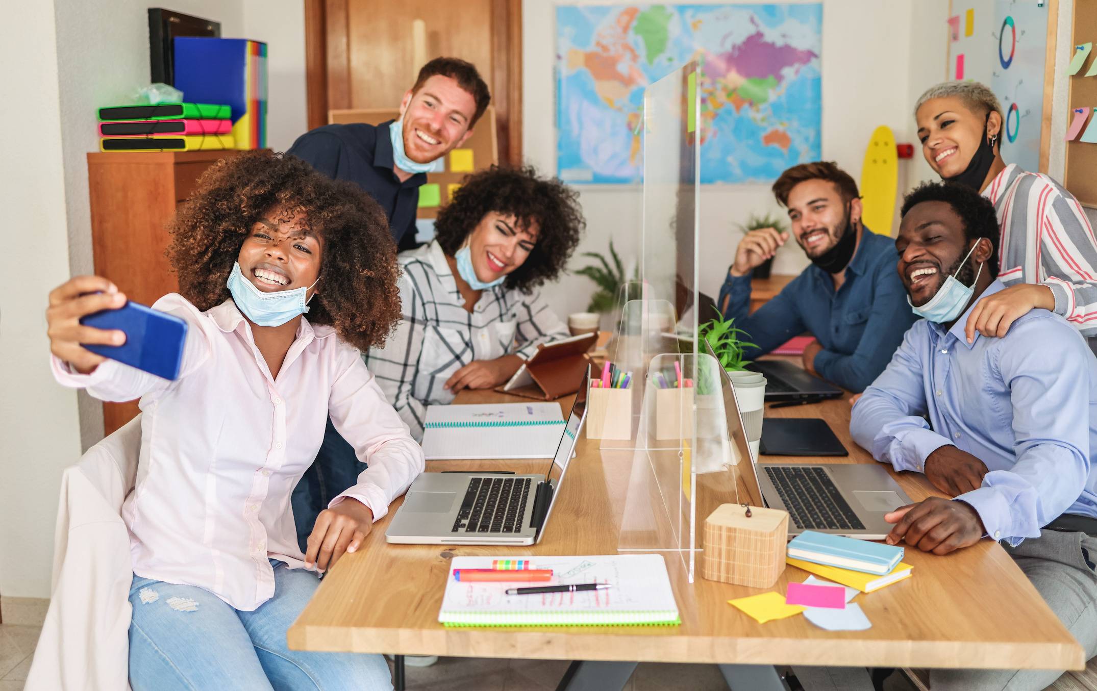 Group of people posing for a selfie while seated around a conference table