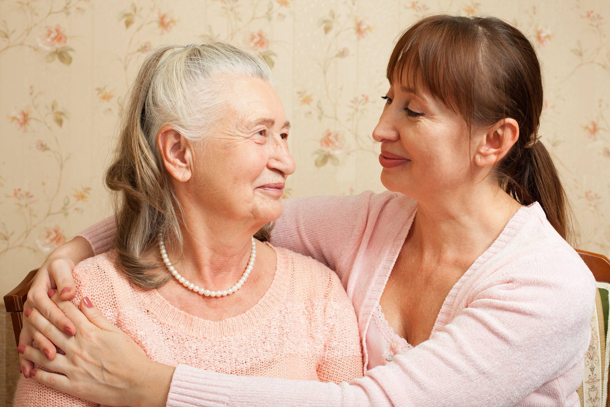 Elderly care worker embracing an elderly patient