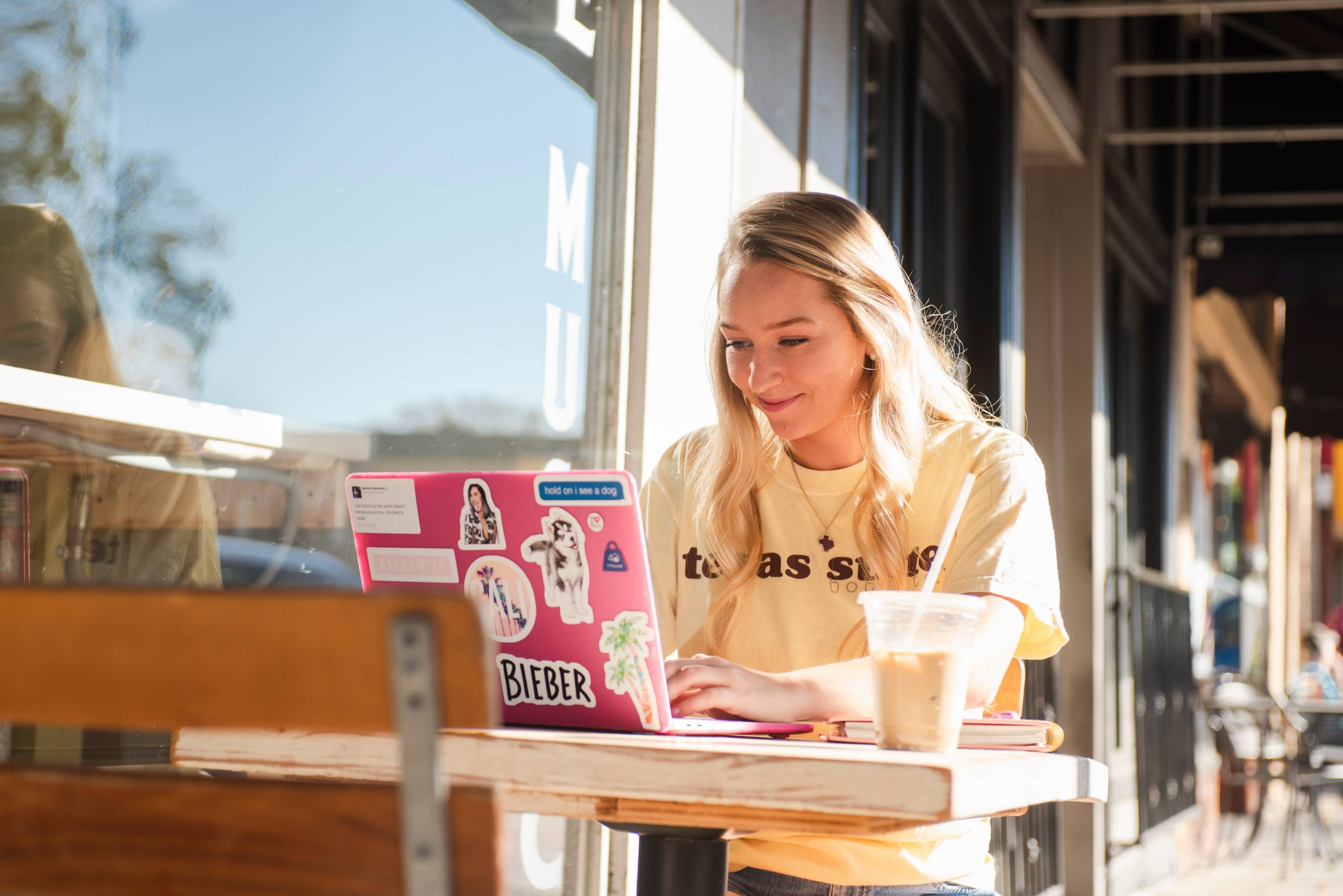 Student sitting at a table with their laptop