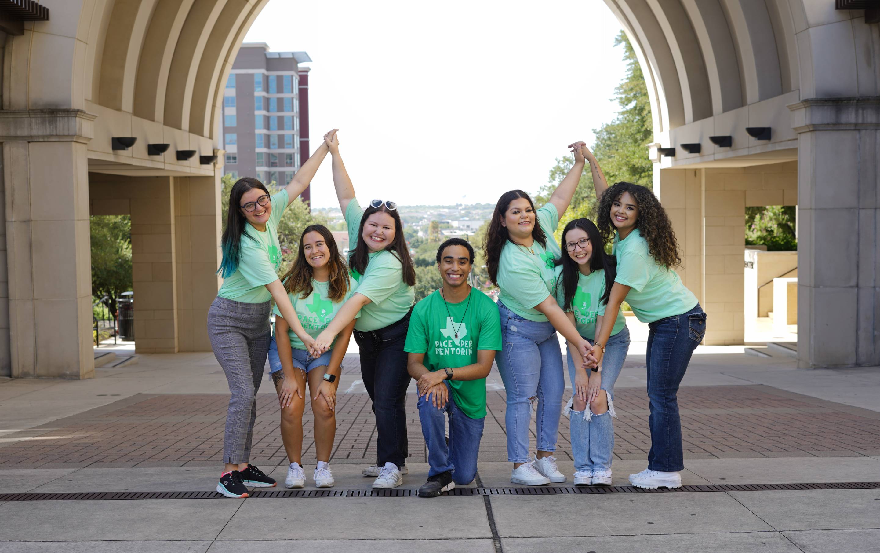 A group of Peer Mentors in front of the UAC arch.