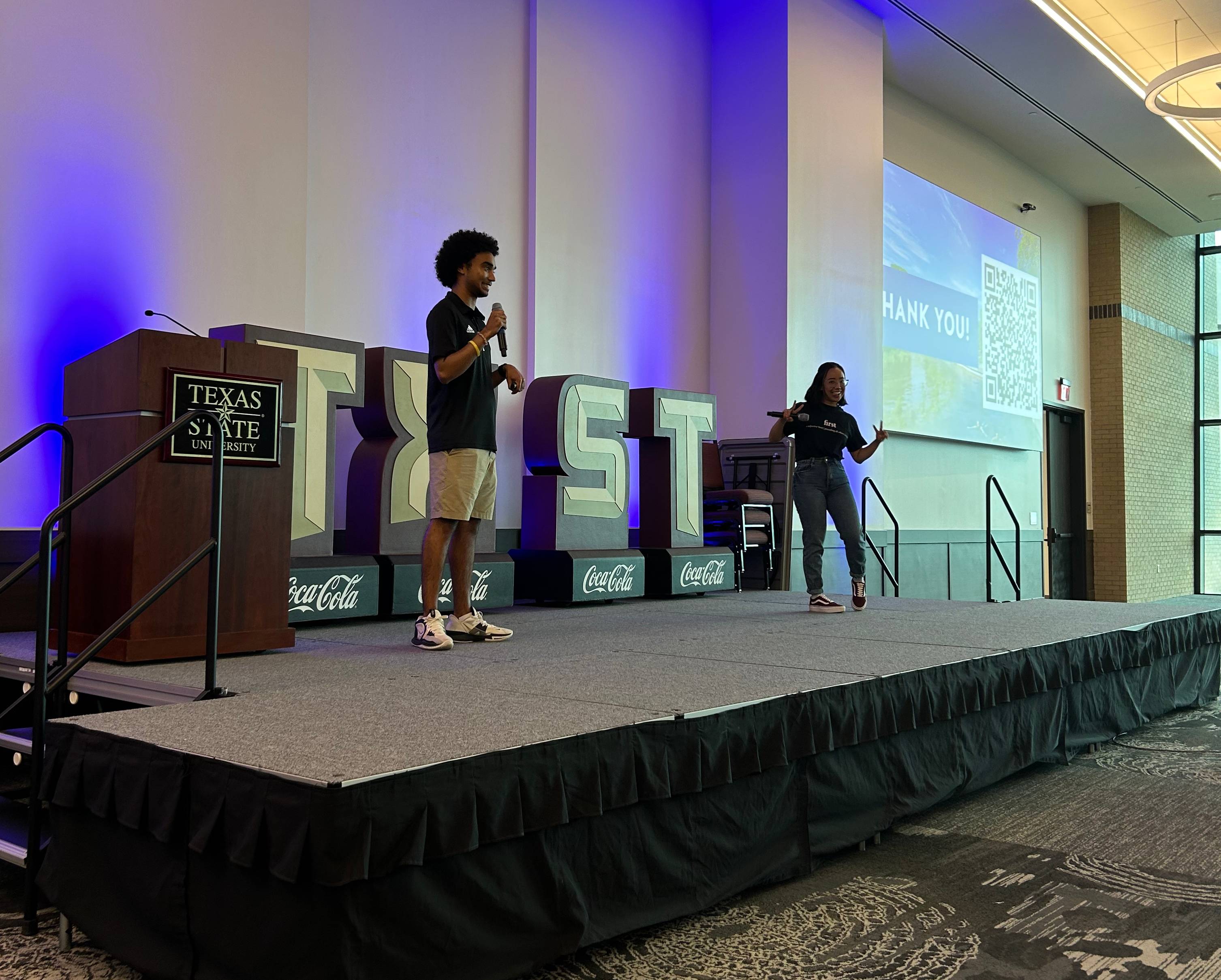 Two peer mentors presenting in the LBJ Grand Ballroom at New Student Orientation.