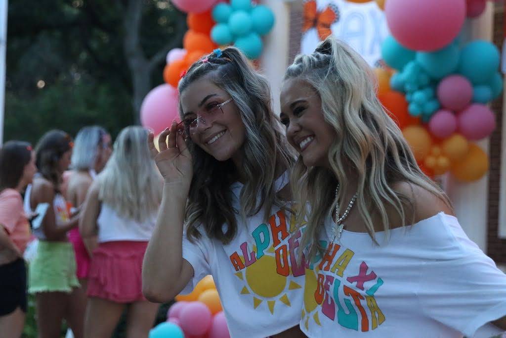 Panhellenic women standing in front of a balloon arch background