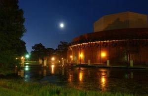 The drama & theater building and surrounding ponds at night under a full moon