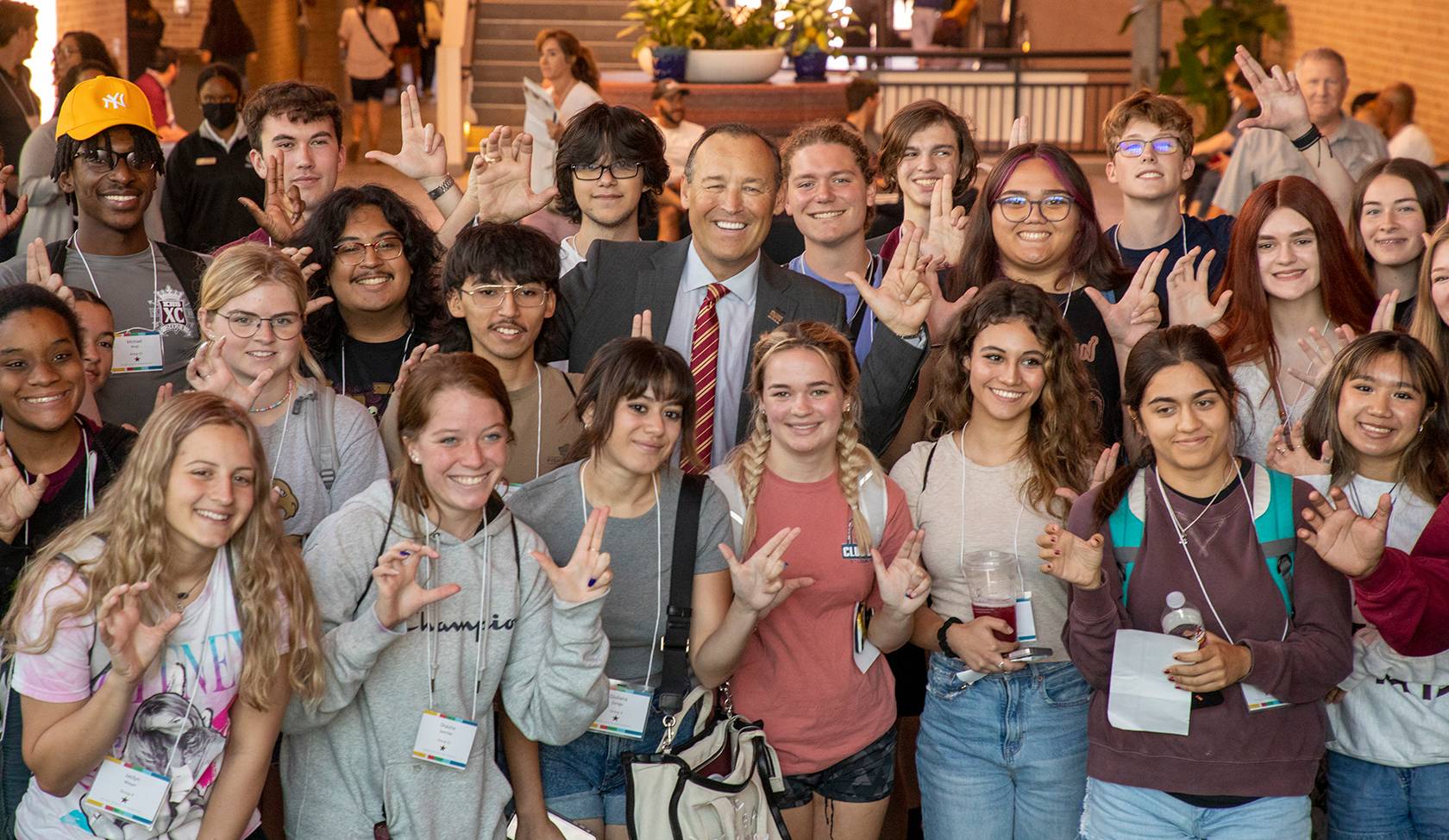 President Damphousse smiling with a group of students