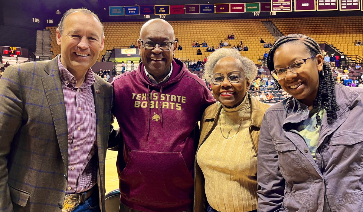President Kelly Damphousse smiling with Johnny Brown and family