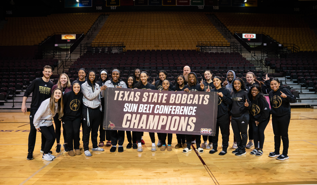 womens basketball team holding up a banner
