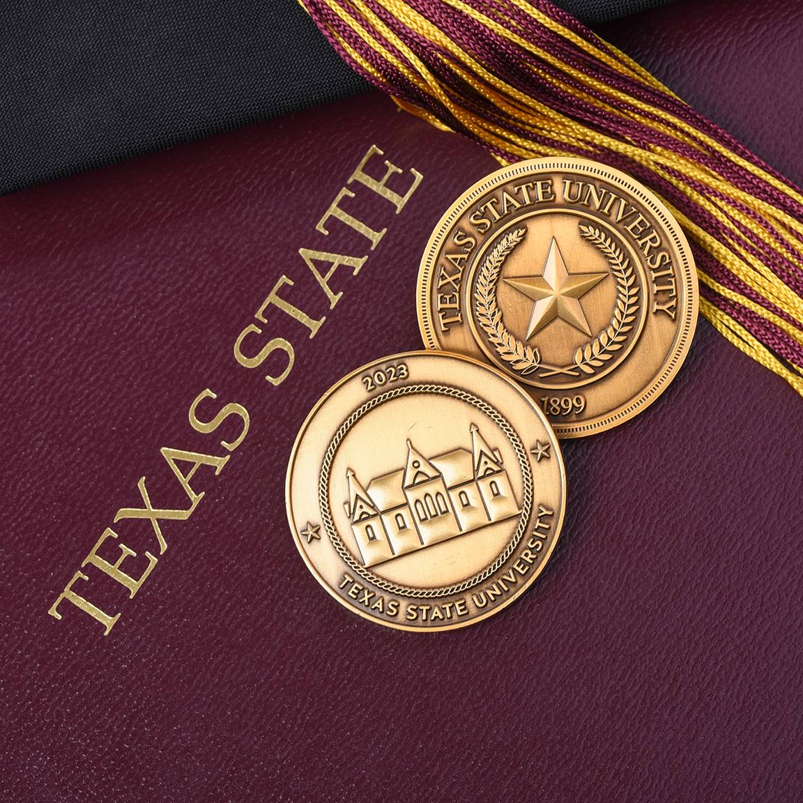 two challenge coins on maroon background reading 'texas state' in gold