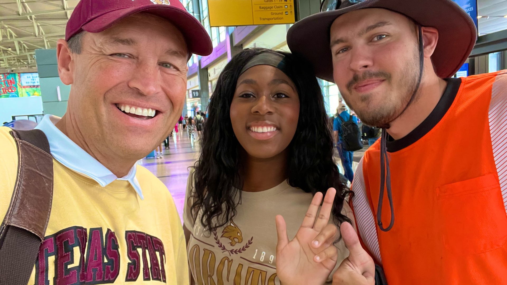 President Damphousse takes a selfie with two TXST Bobcats in the Austin Airport.
