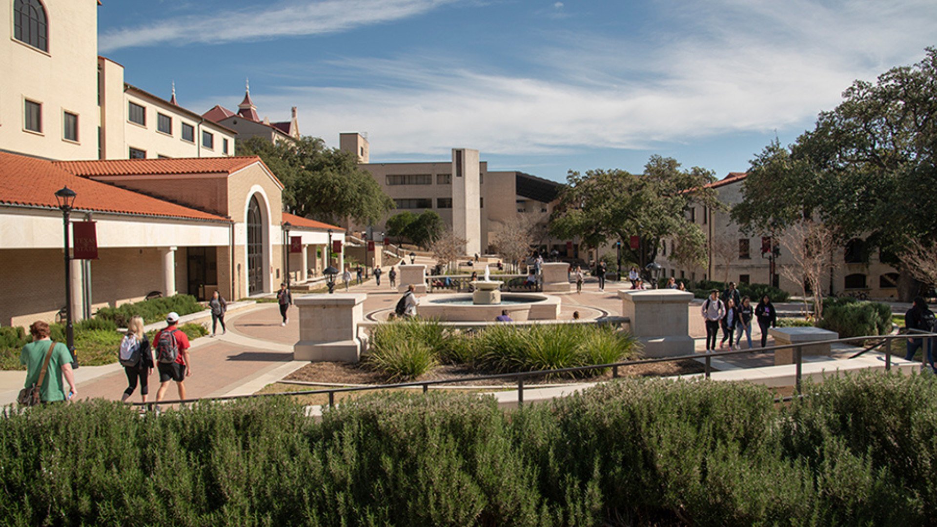 Shot of the San Marcos Campus with students walking along Bobcat Trail.
