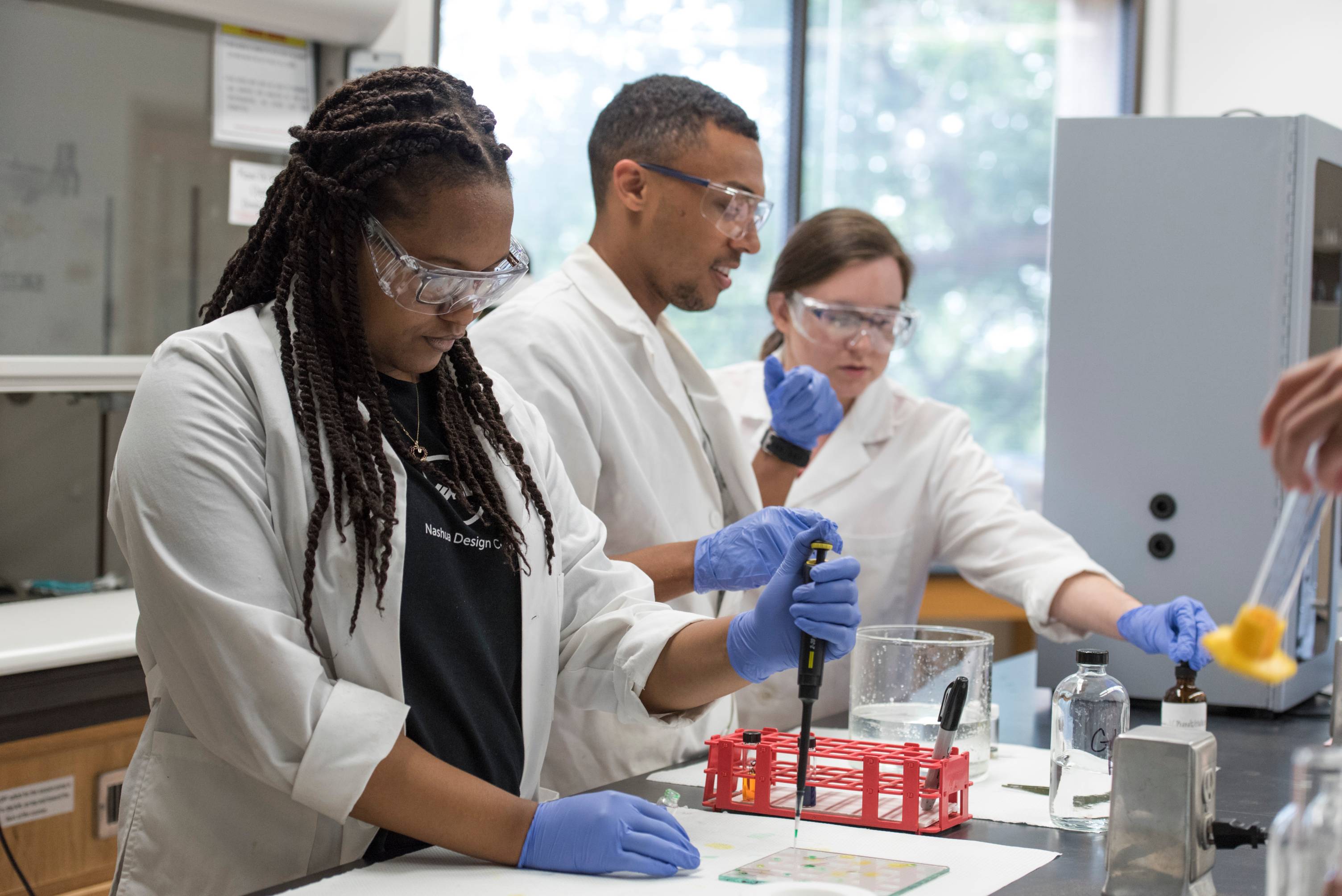 three students conducting a scientific lab