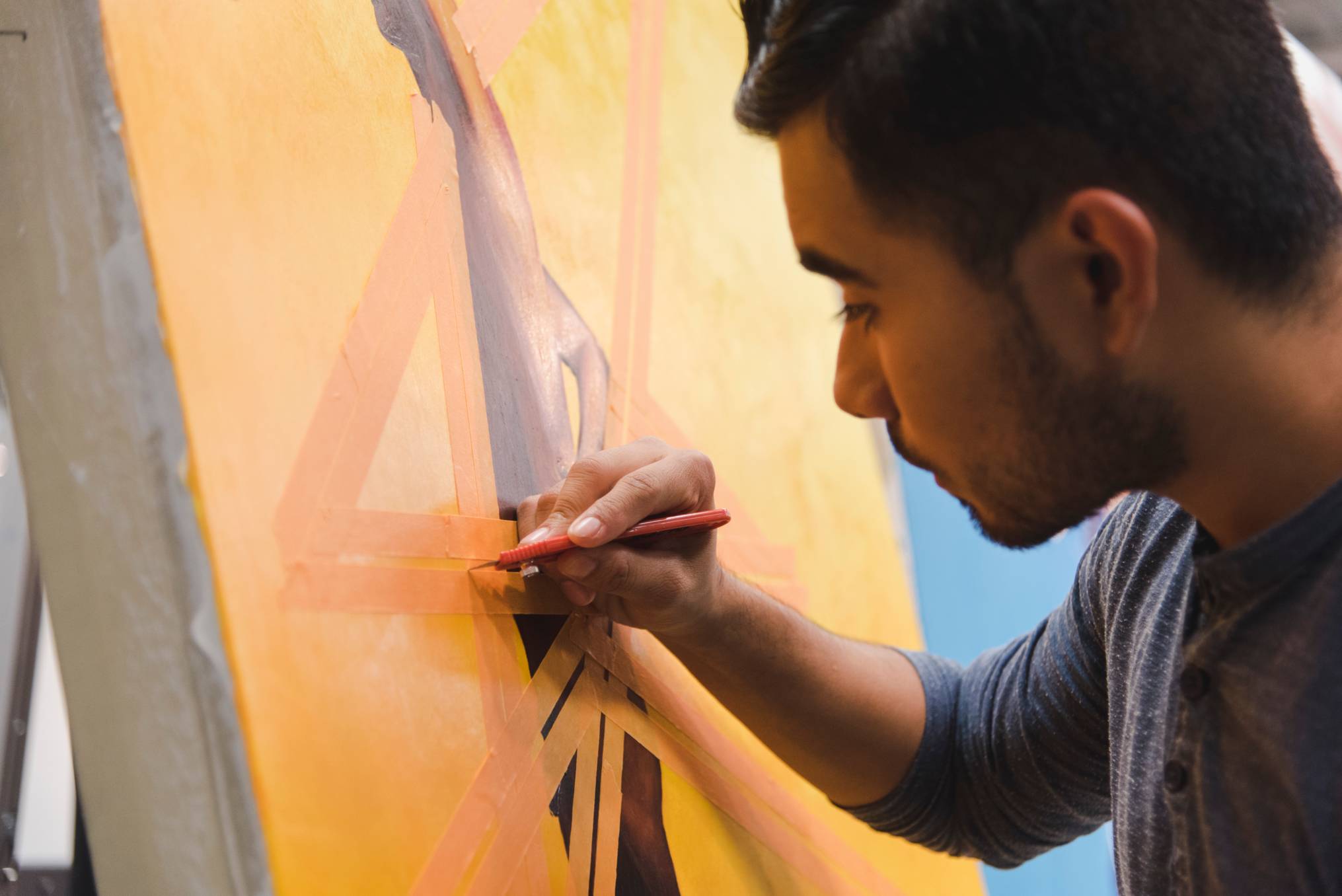 a male student painting on canvas