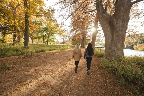 Two people walking with fall scenery