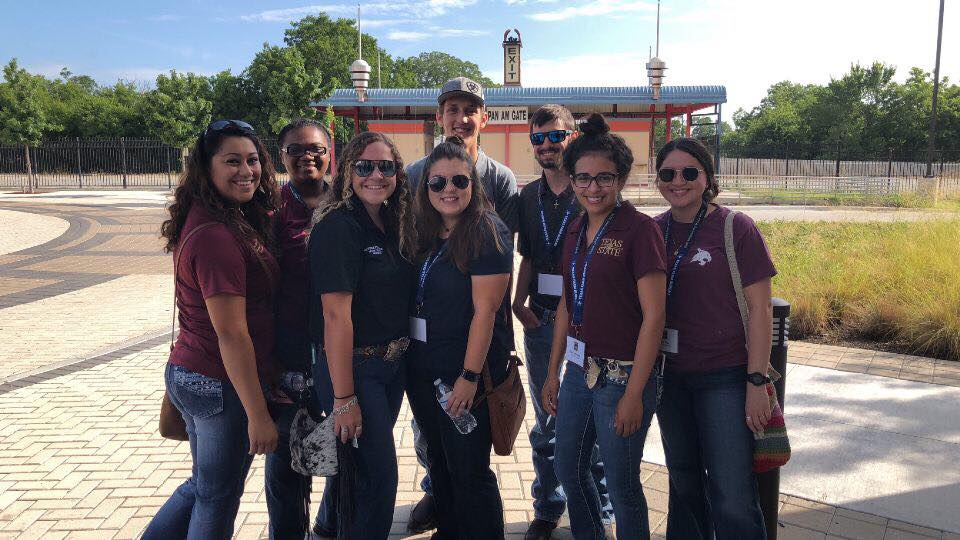 Students in Texas State shirts smiling