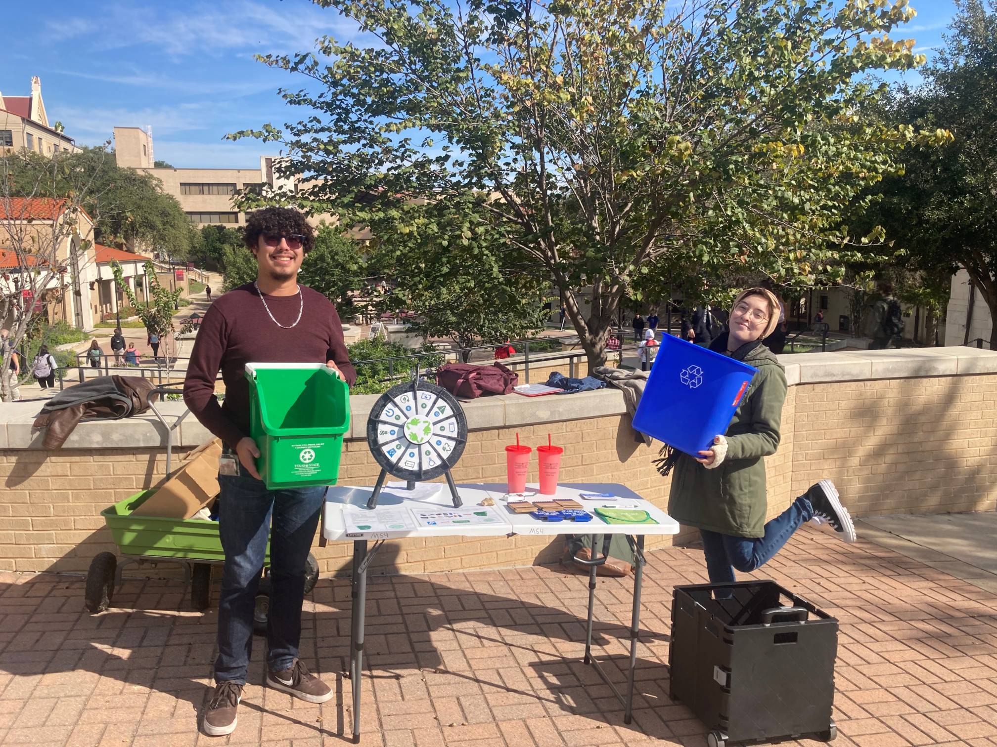 Two student workers tabling on the Quad to educate students about recycling opportunities on campus.