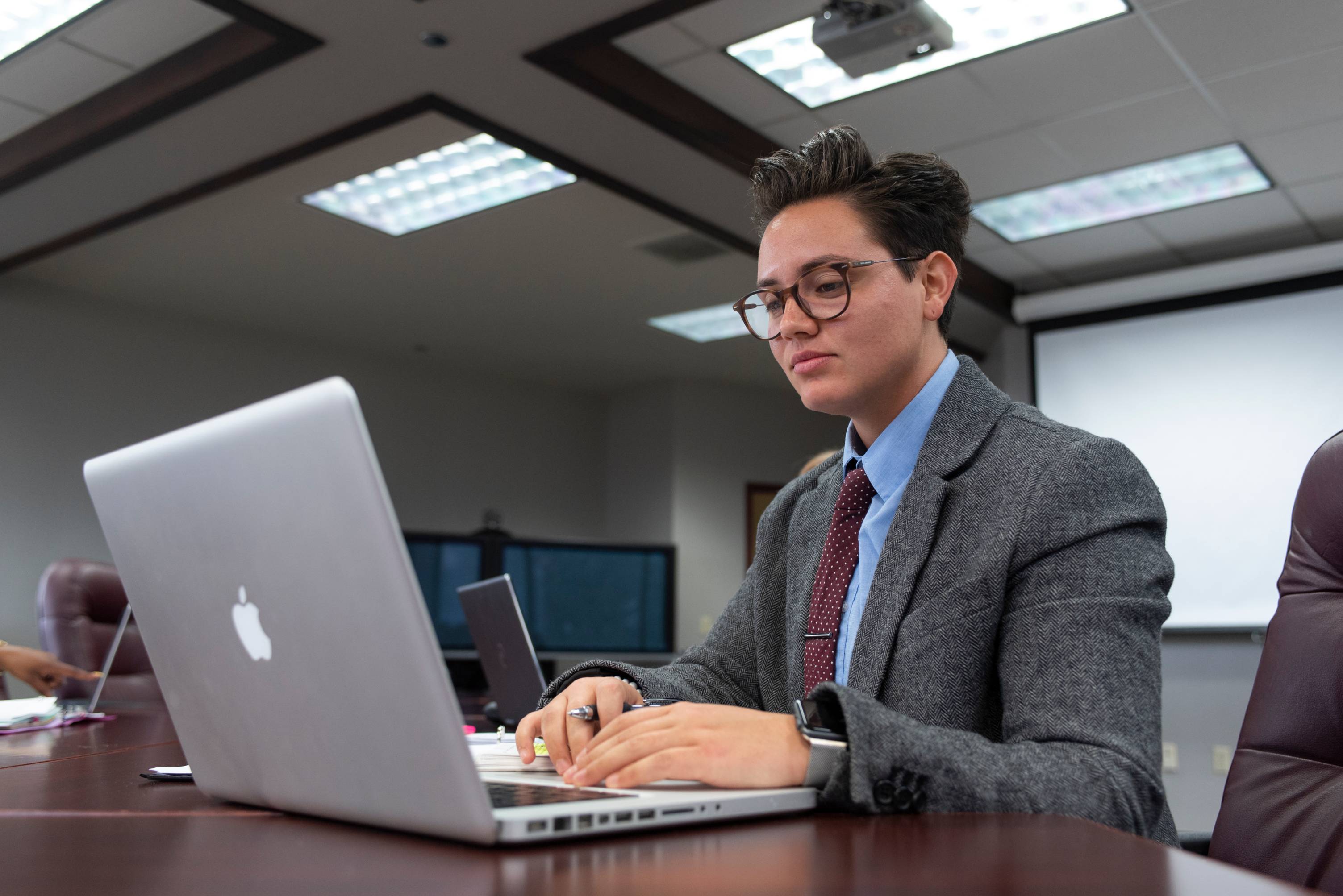 a person typing on their laptop wearing professional clothes