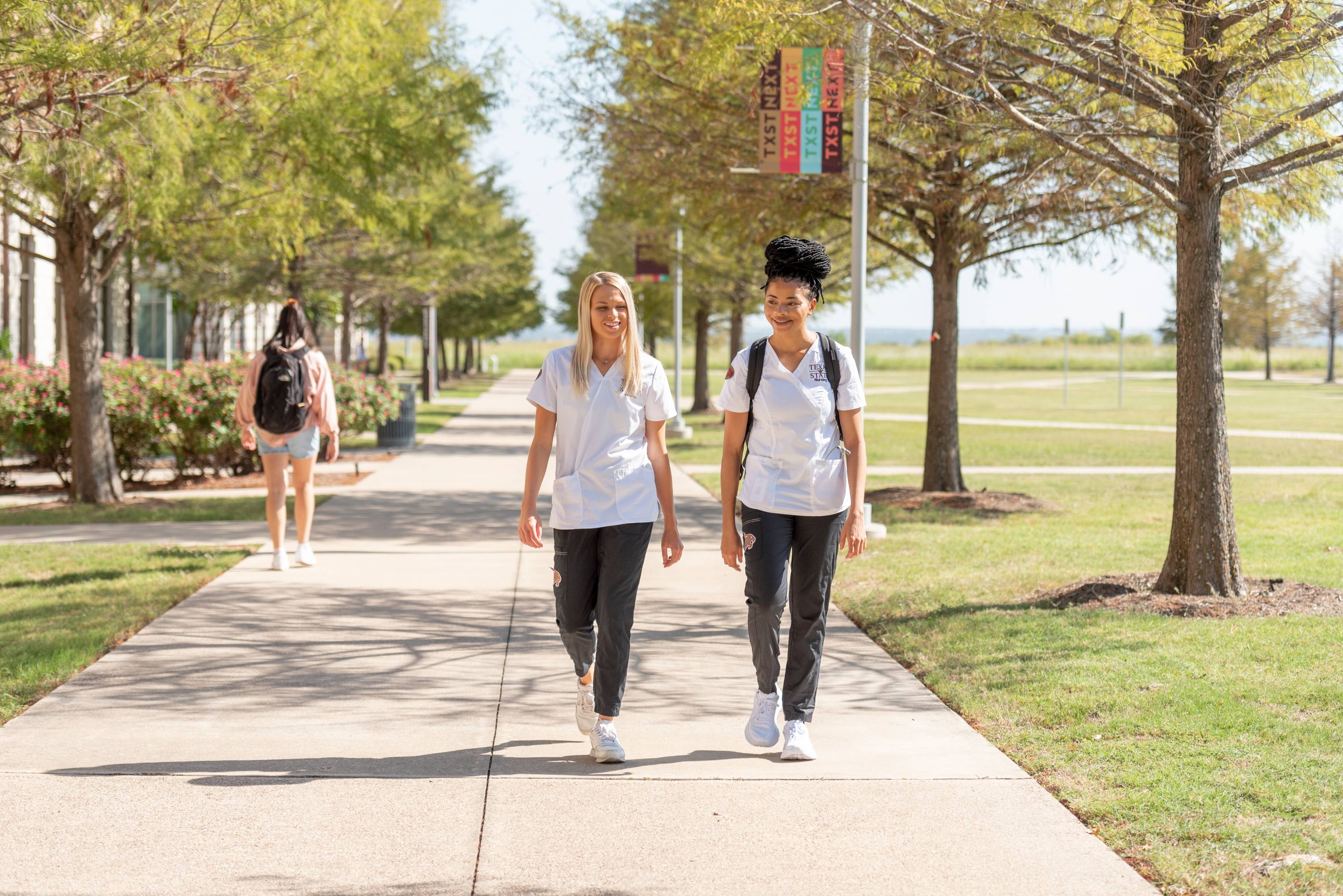 two students talking while walking outside