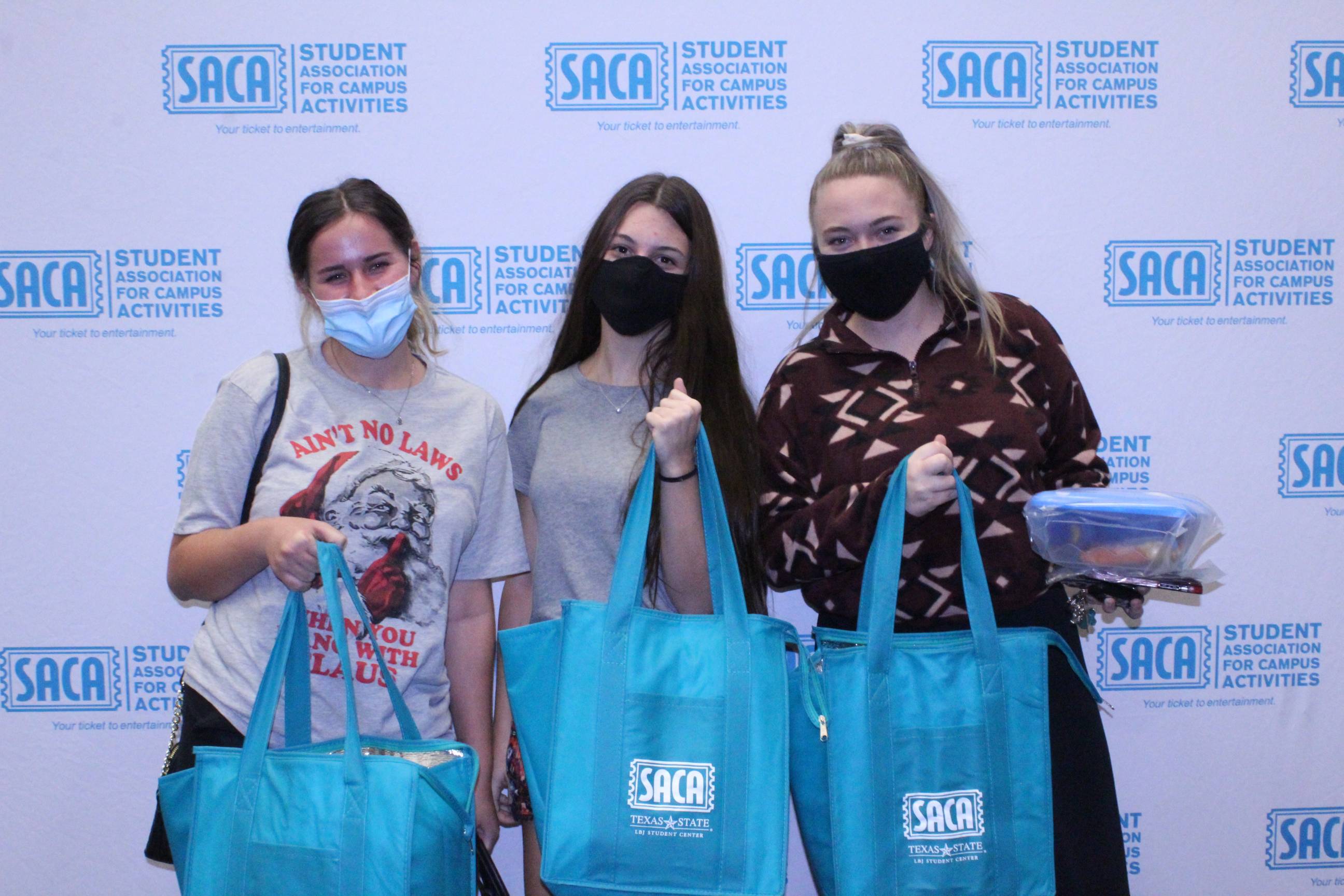 Three students holding SACA Grocery Bags