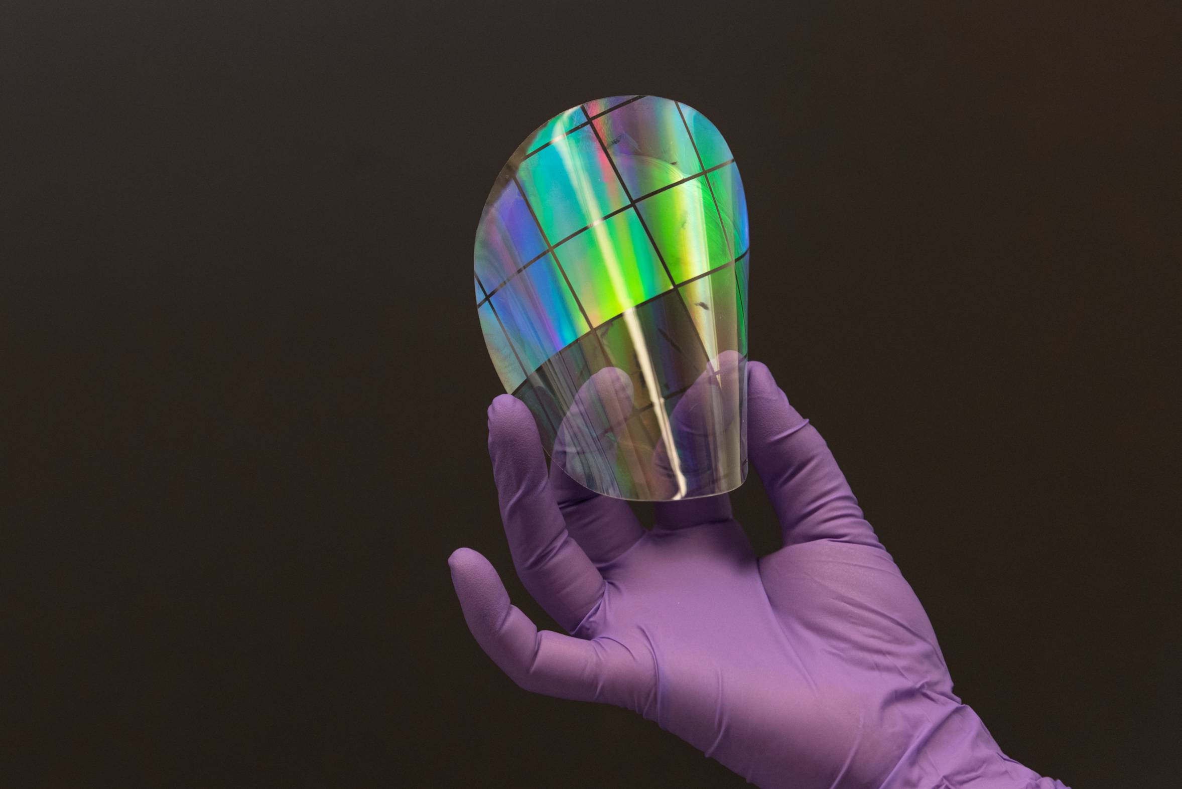 Image of hand holding a piece of a smart flexible material.