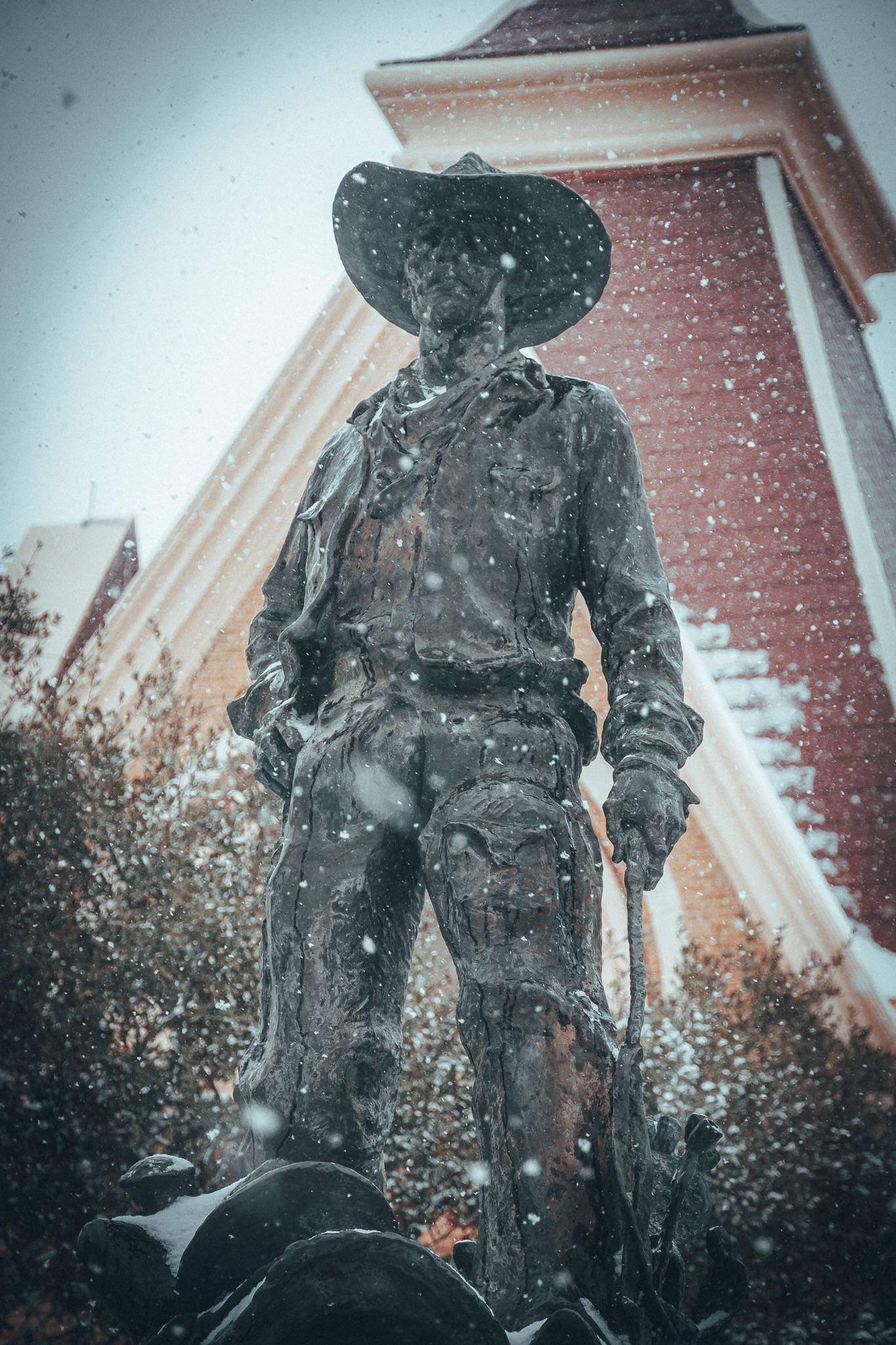Snow falling on statue