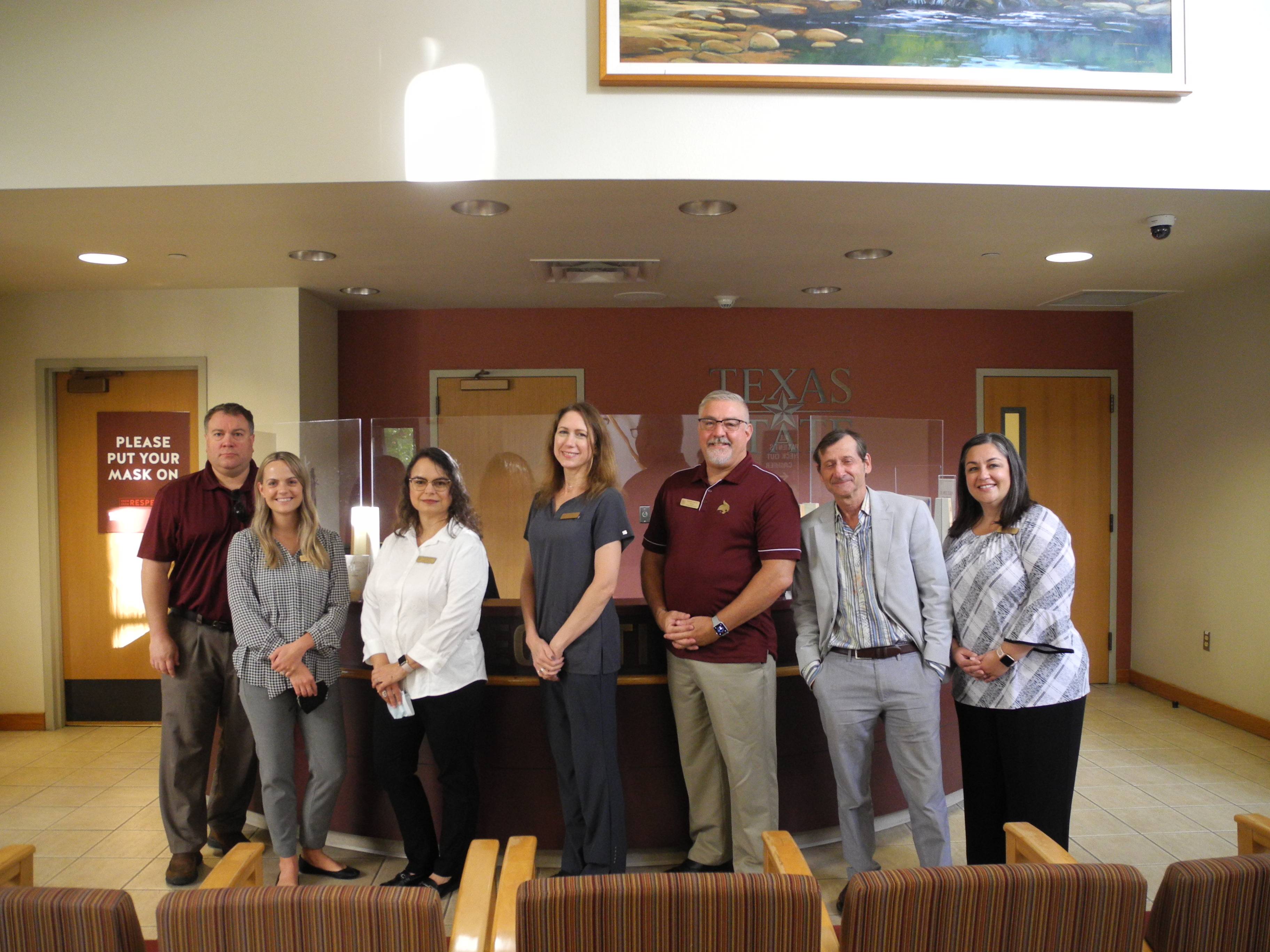 Group of Student Health Center providers standing inside the lobby of the Student Health Center.