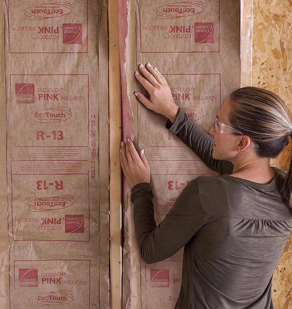 person installing insulation in their home